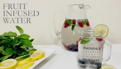 A glass pitcher and a glass filled with fruit-infused water. 