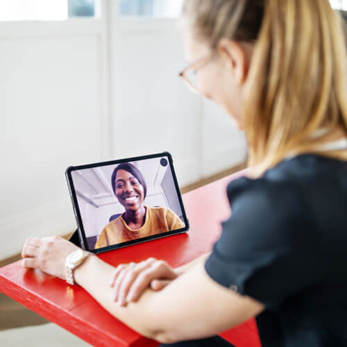 A woman watches a webinar on a tablet