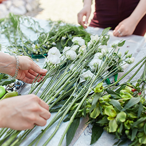 Woman laying out an assortment of wildflowers and greenery on a table