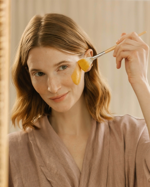 a woman applying the Turmeric Energizing Treatment