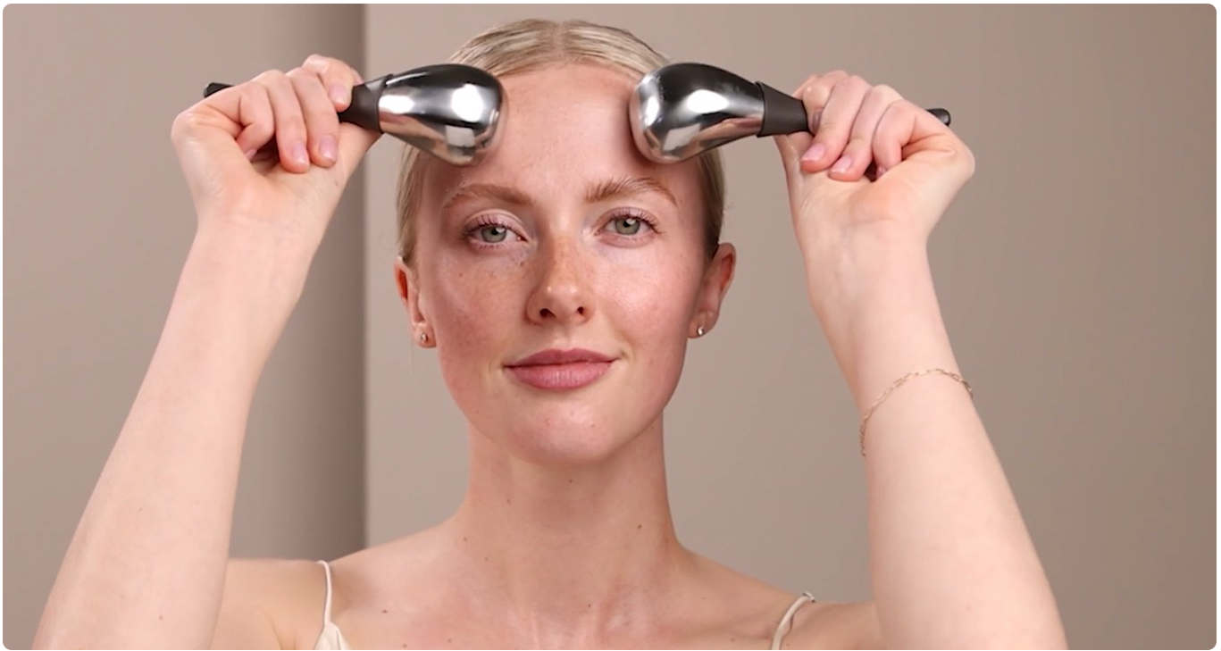 Woman holding Cryo-Thermal Tools to face