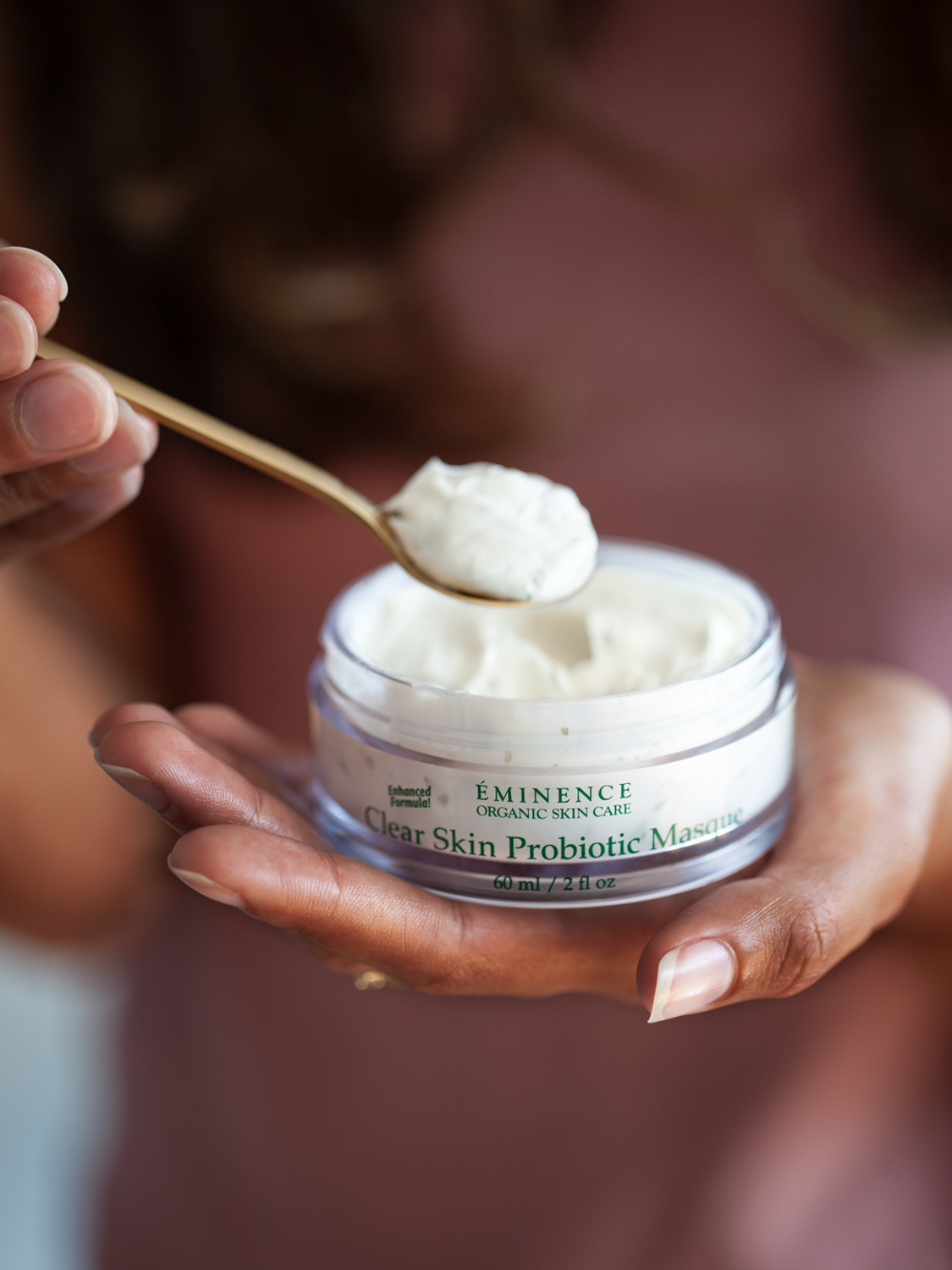 A woman holding Eminence Organics Clear Skin Probiotic Masque