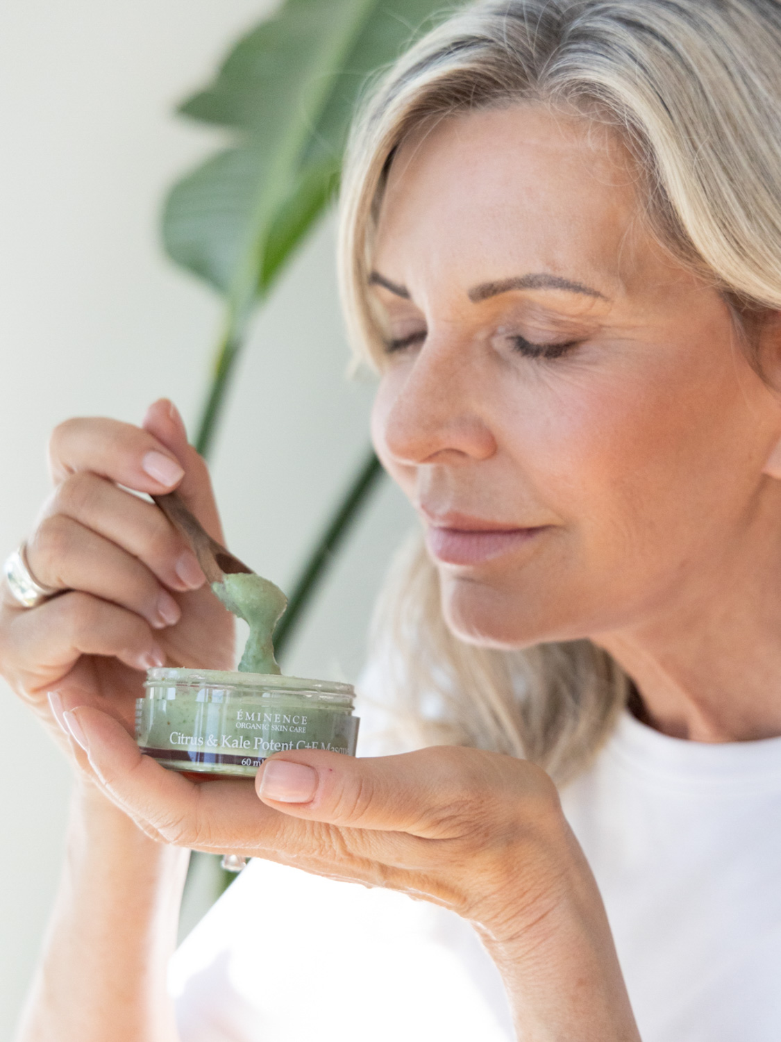 A woman holding Eminence Organics Citrus & Kale Potent C+E Serum