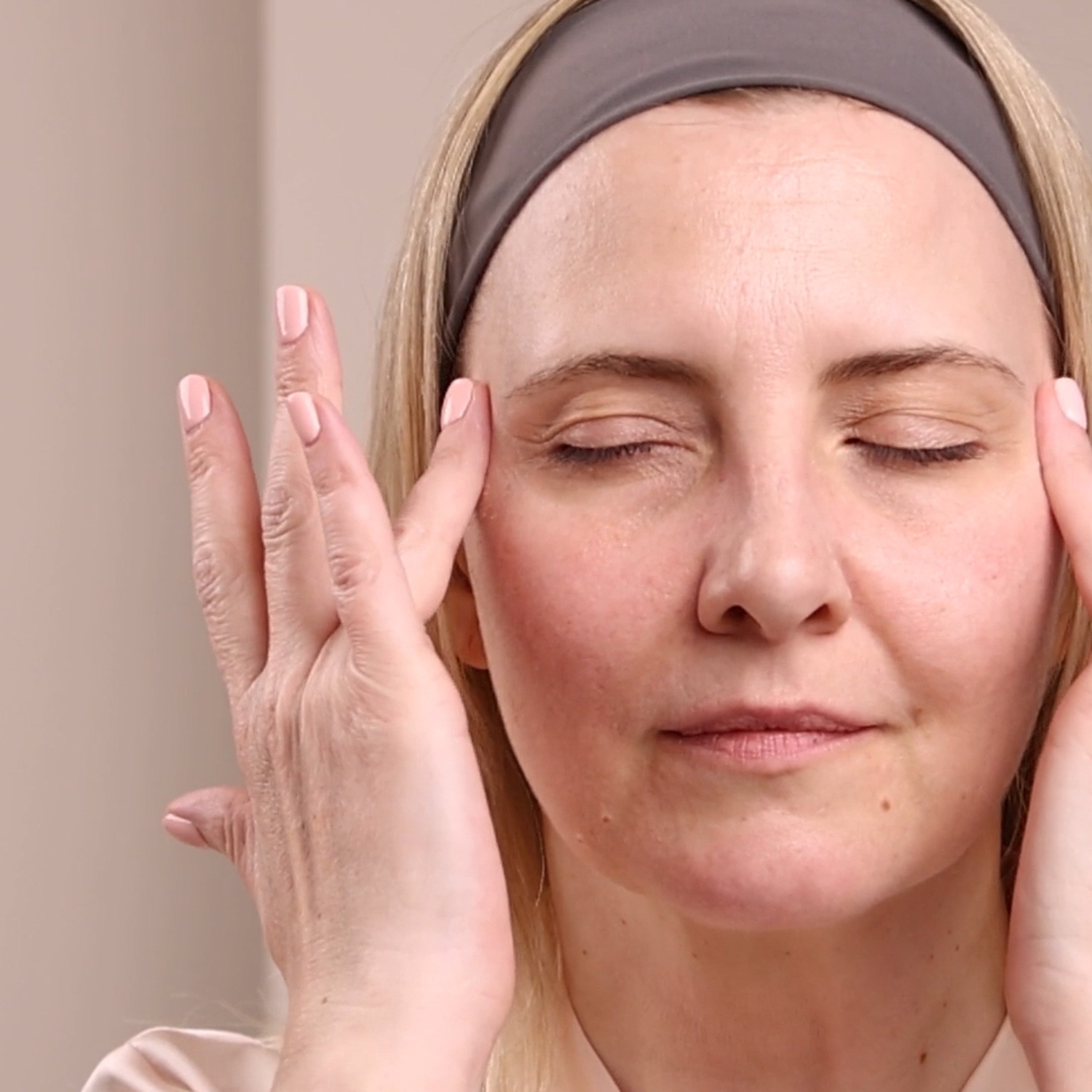 A woman applying Eminence Organics Bearberry Eye Repair Cream to face