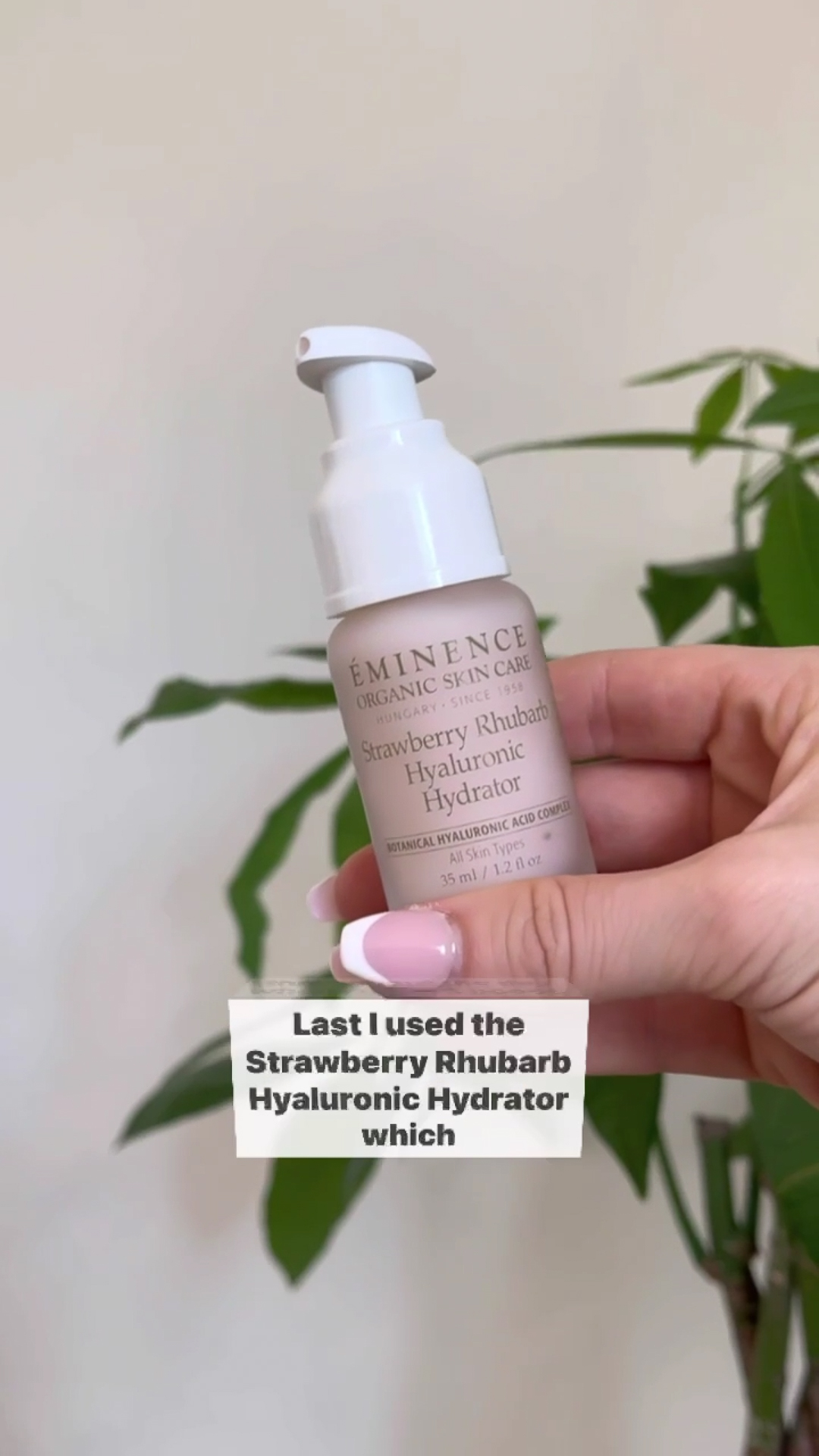 A hand holding the Eminence Organics Strawberry Rhubarb Hyaluronic Hydrator