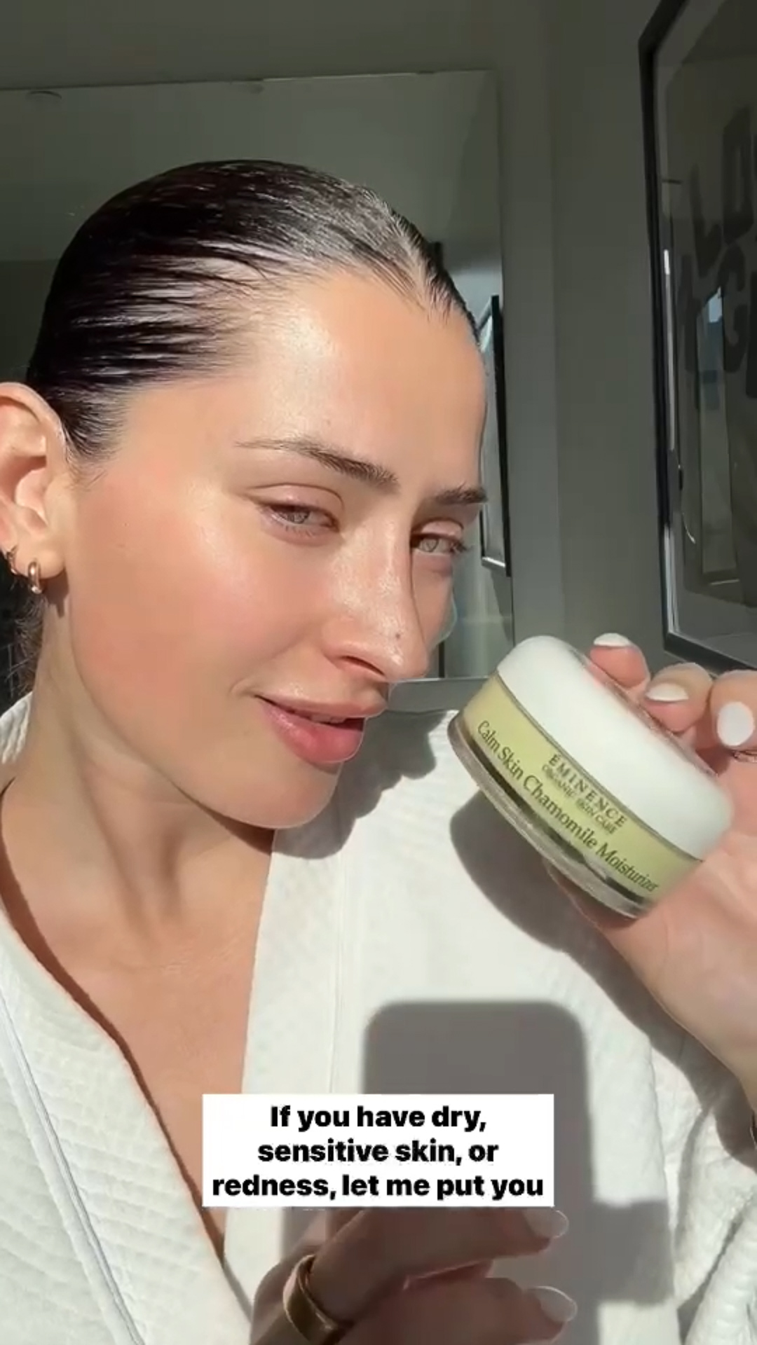 A woman holding Eminence Organics Chamomile Moisturizer