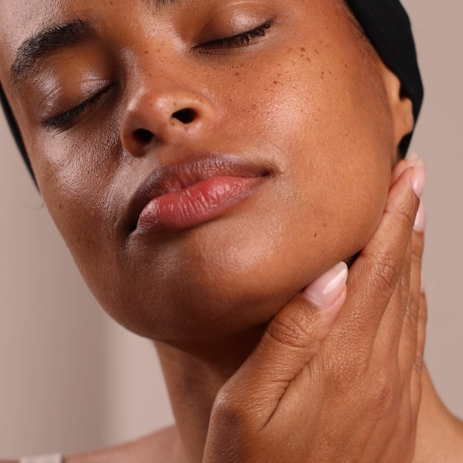 A woman applying the Eminence Organics Kombucha Microbiome Balancing Essence on her neck