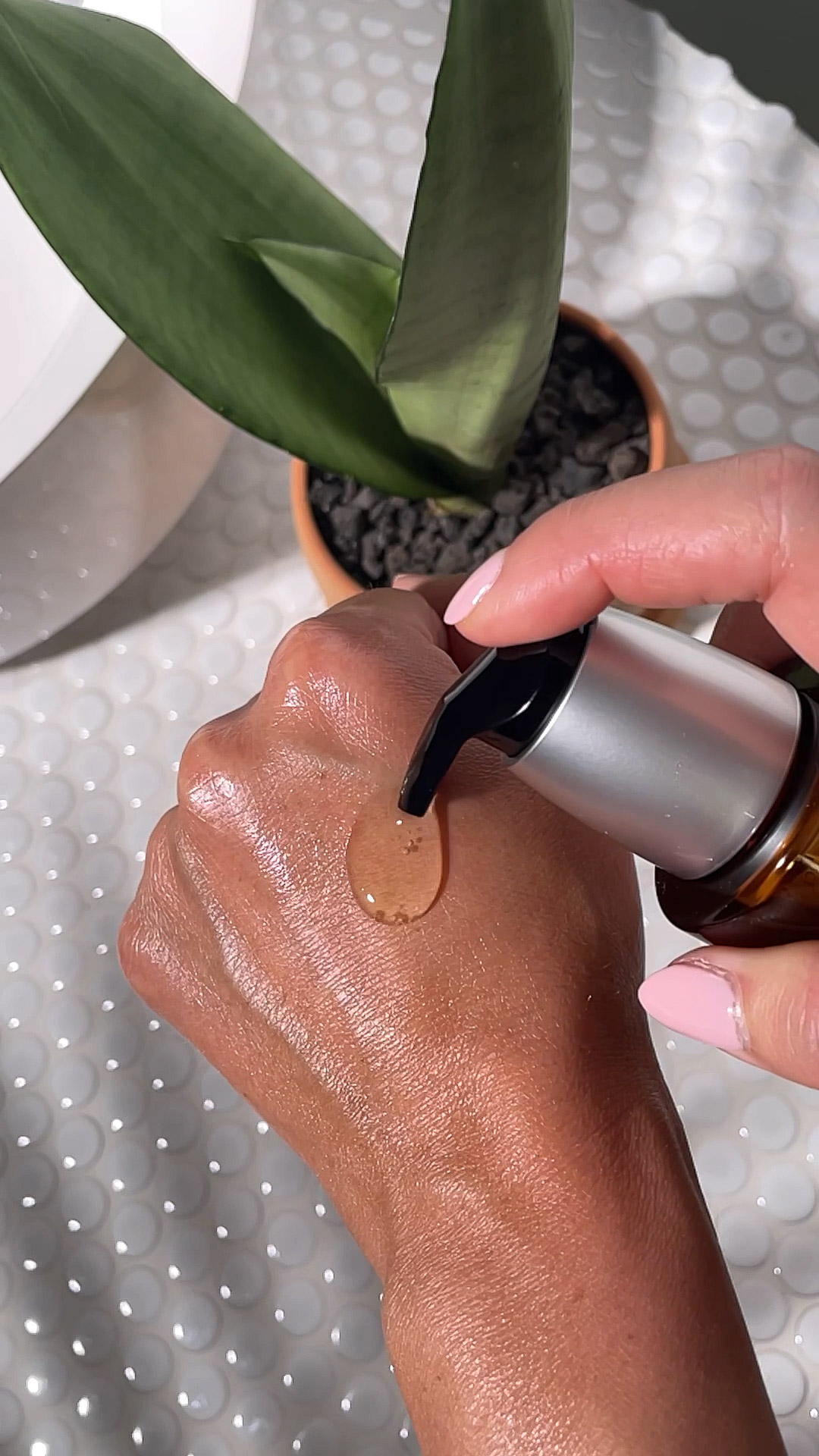 A person applying the Eminence Organics Stone Crop Cleansing Oil on their hand