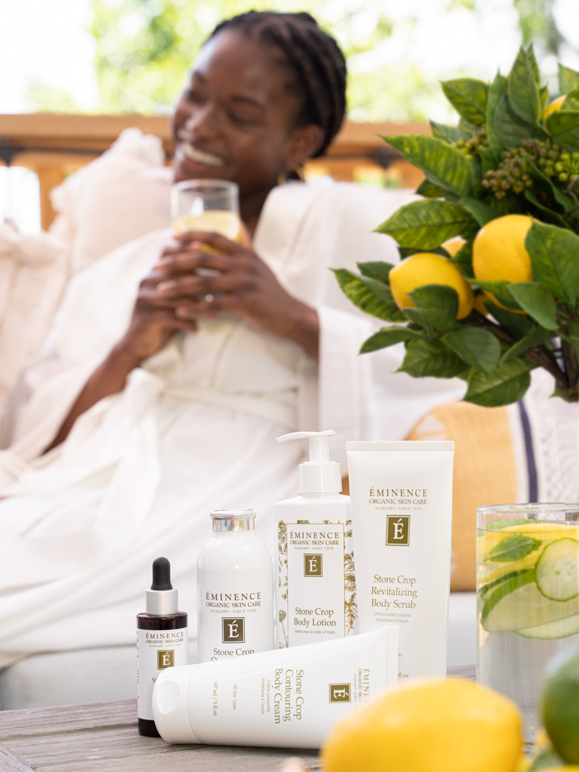 Eminence Organics Stone Crop Collection next to an arrangements of lemons and green leaves