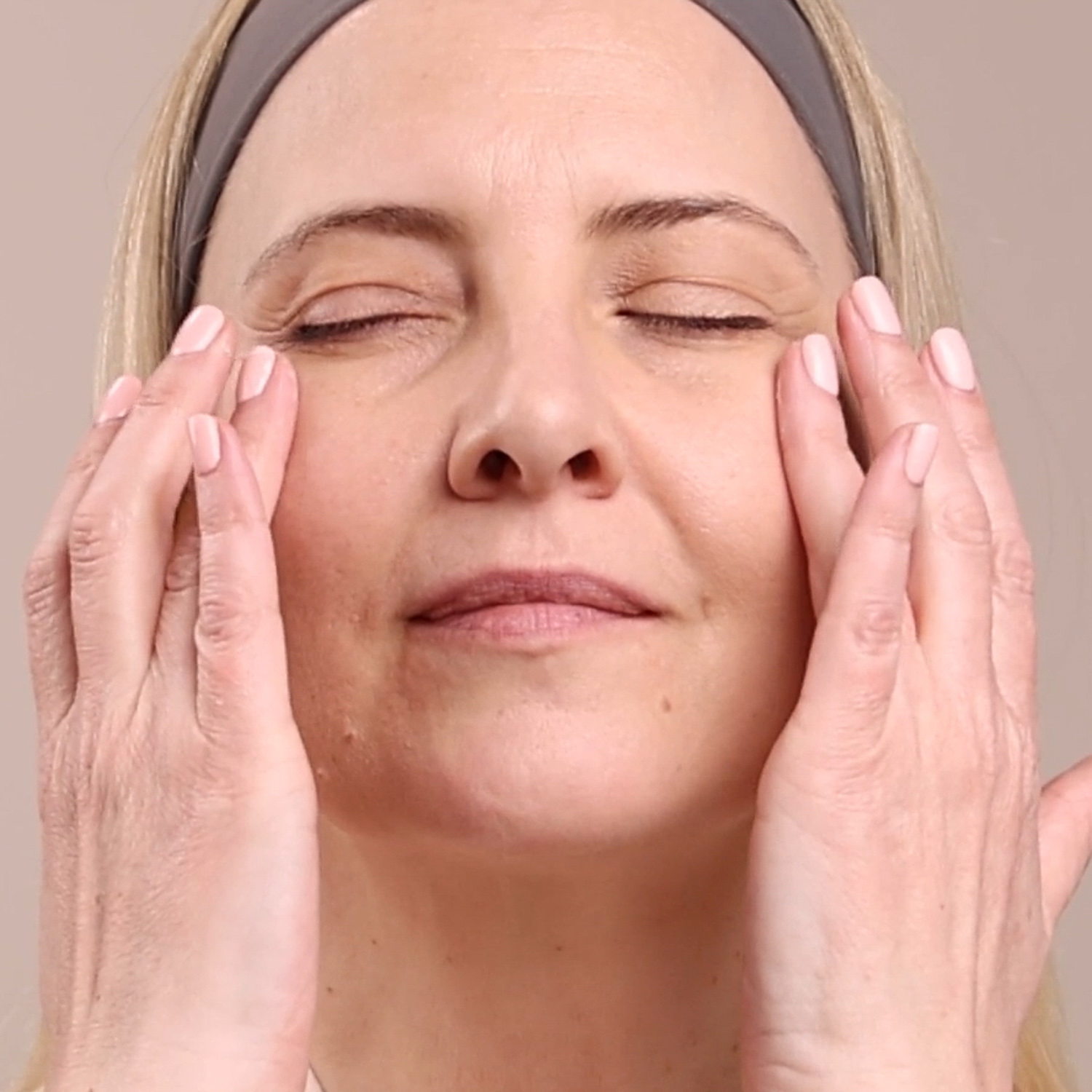 A woman applying the Eminence Organics Snow Mushroom Moisture Cloud Eye Cream under her eyes