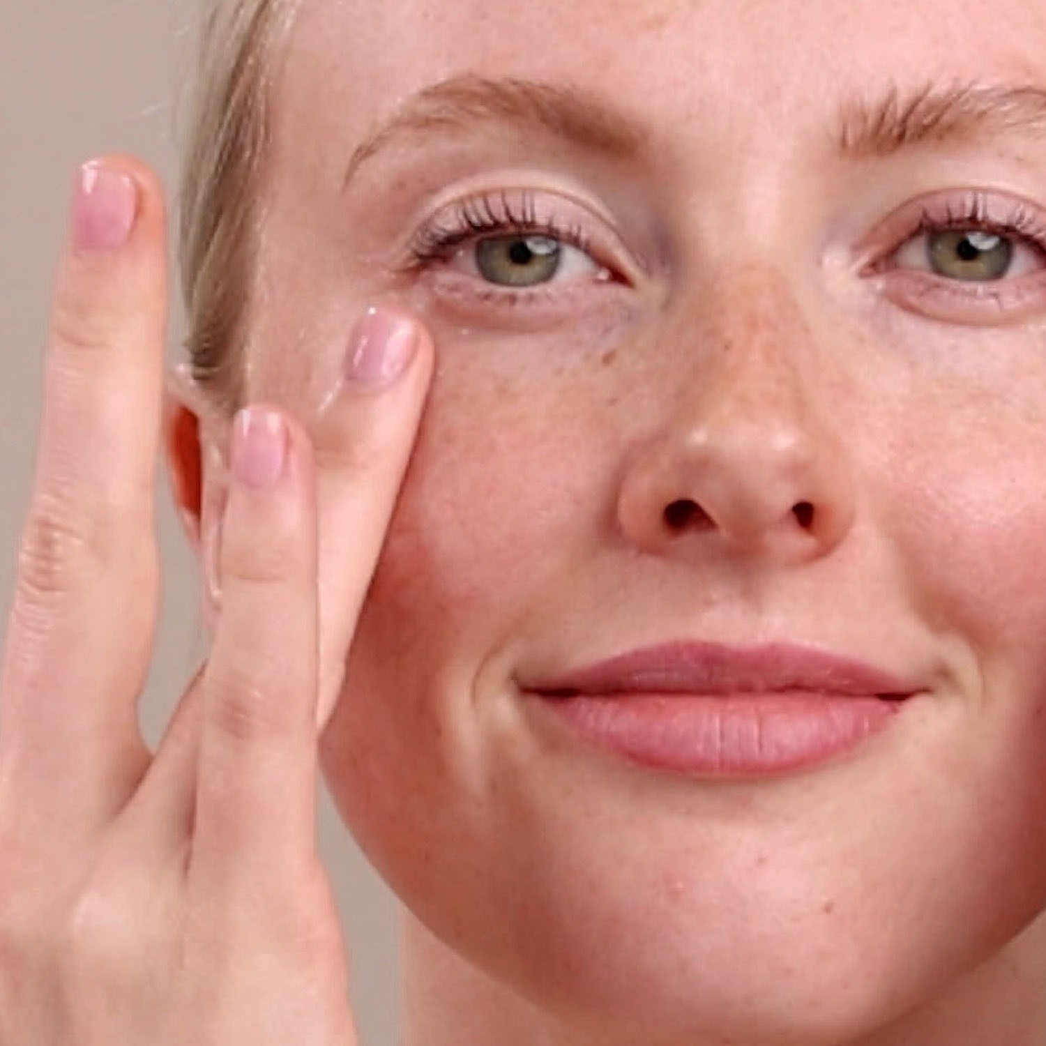 A woman applying the Eminence Organics Marine Flower Peptide Eye Cream to the eye area