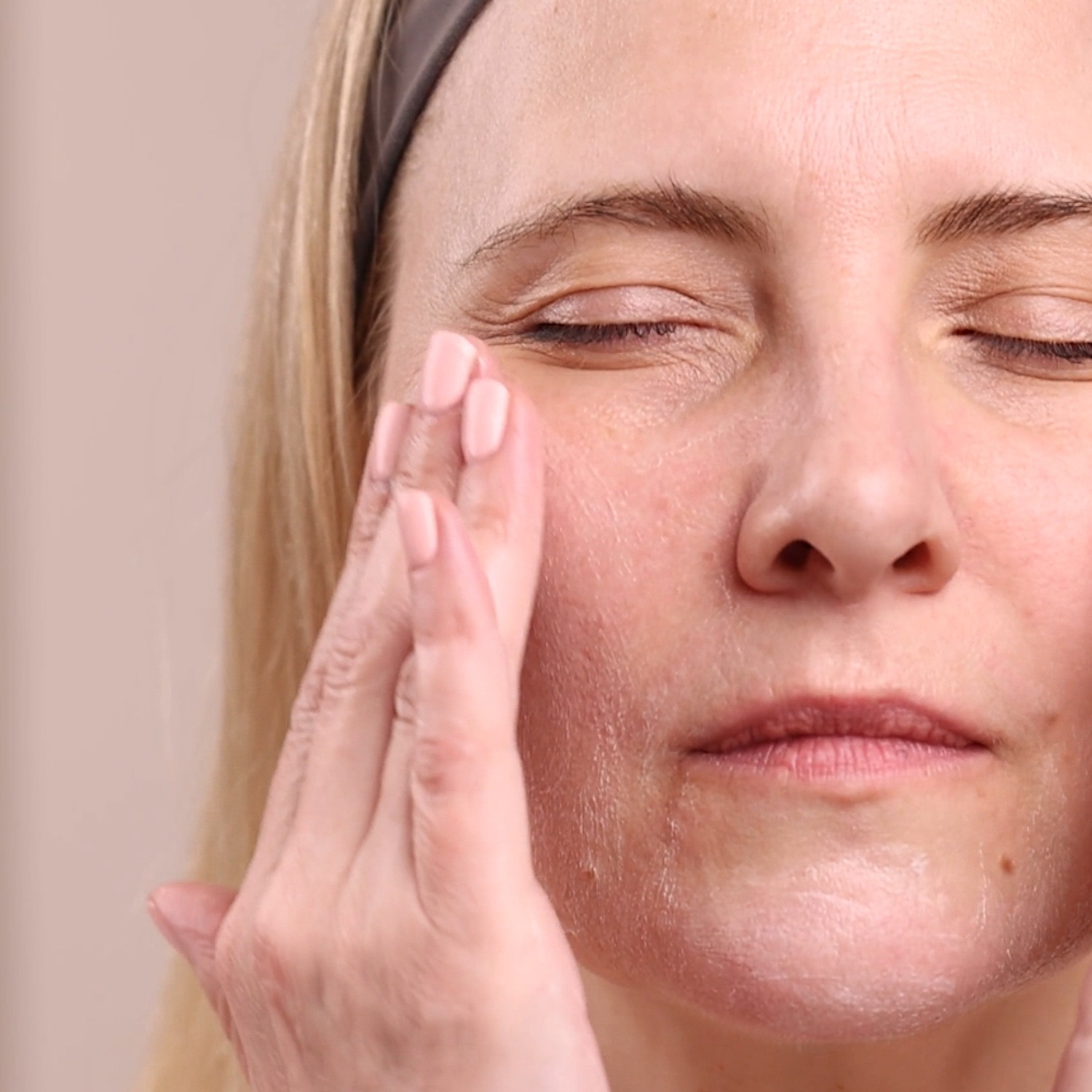 A woman applying Eminence Organics Bright Skin Starter Set to face