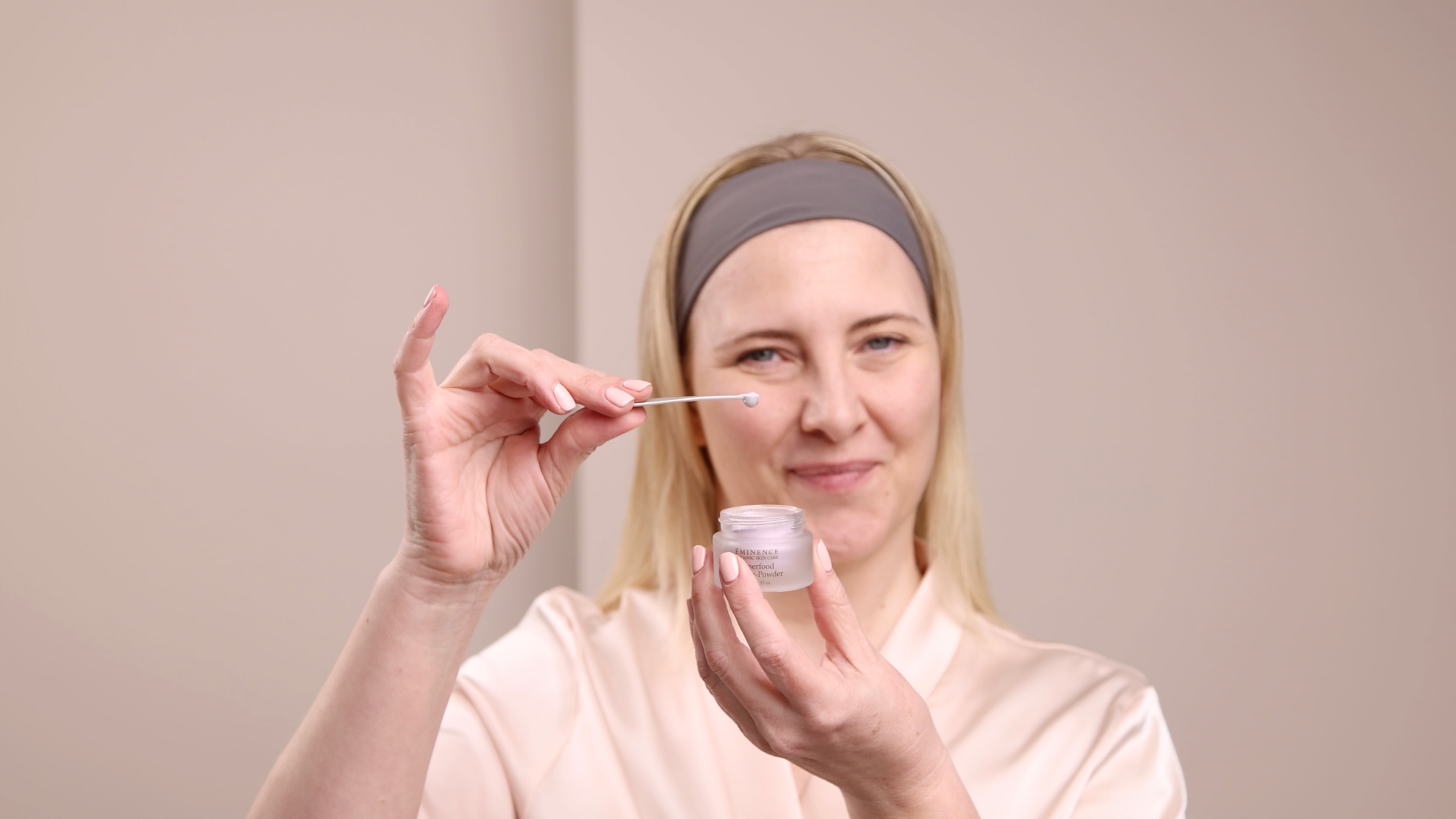 A woman holding the Eminence Organics Superfood Booster-Powder