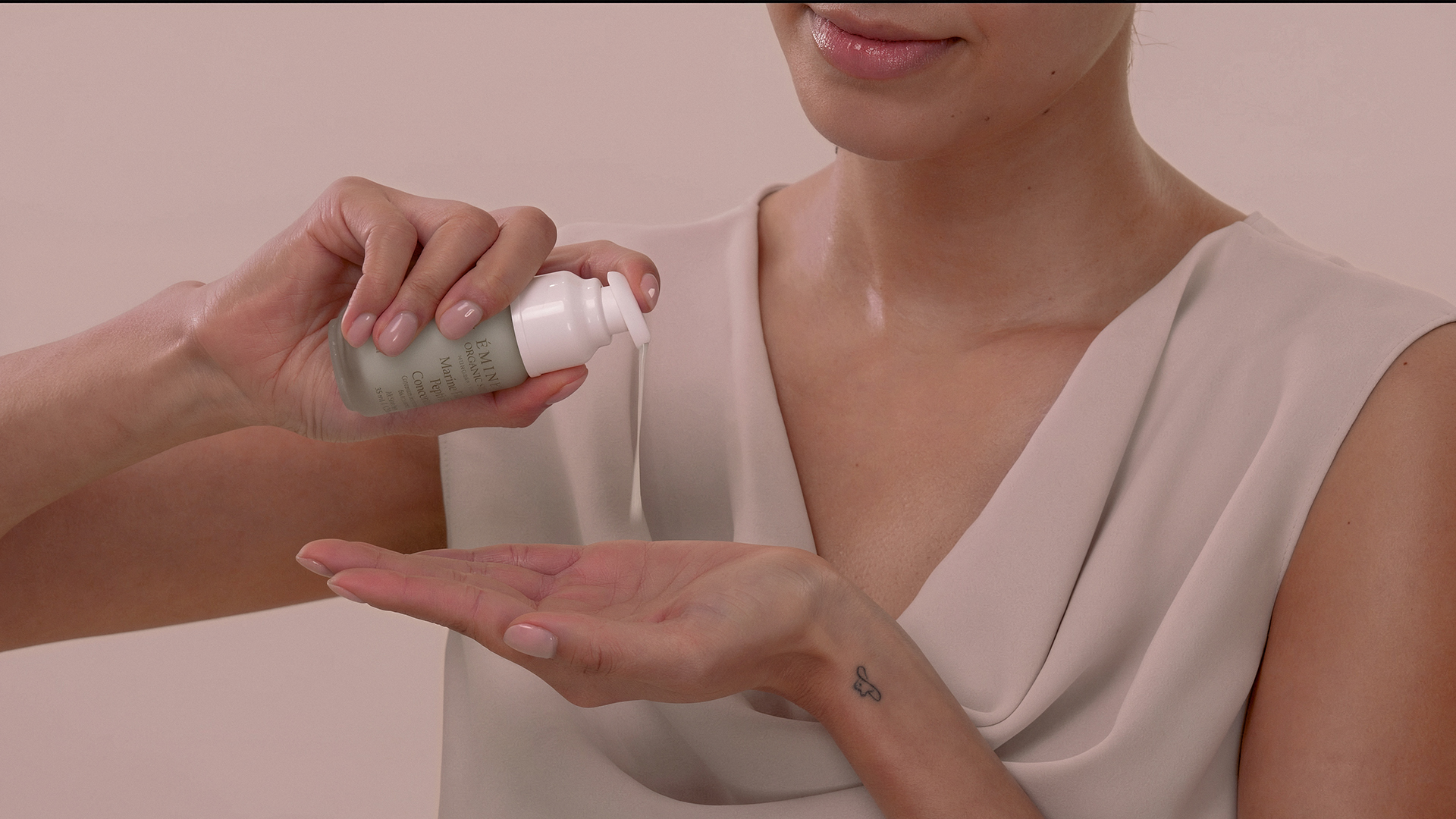 A woman applying the Eminence Organics Marine Flower Peptide Concentrate on her hand