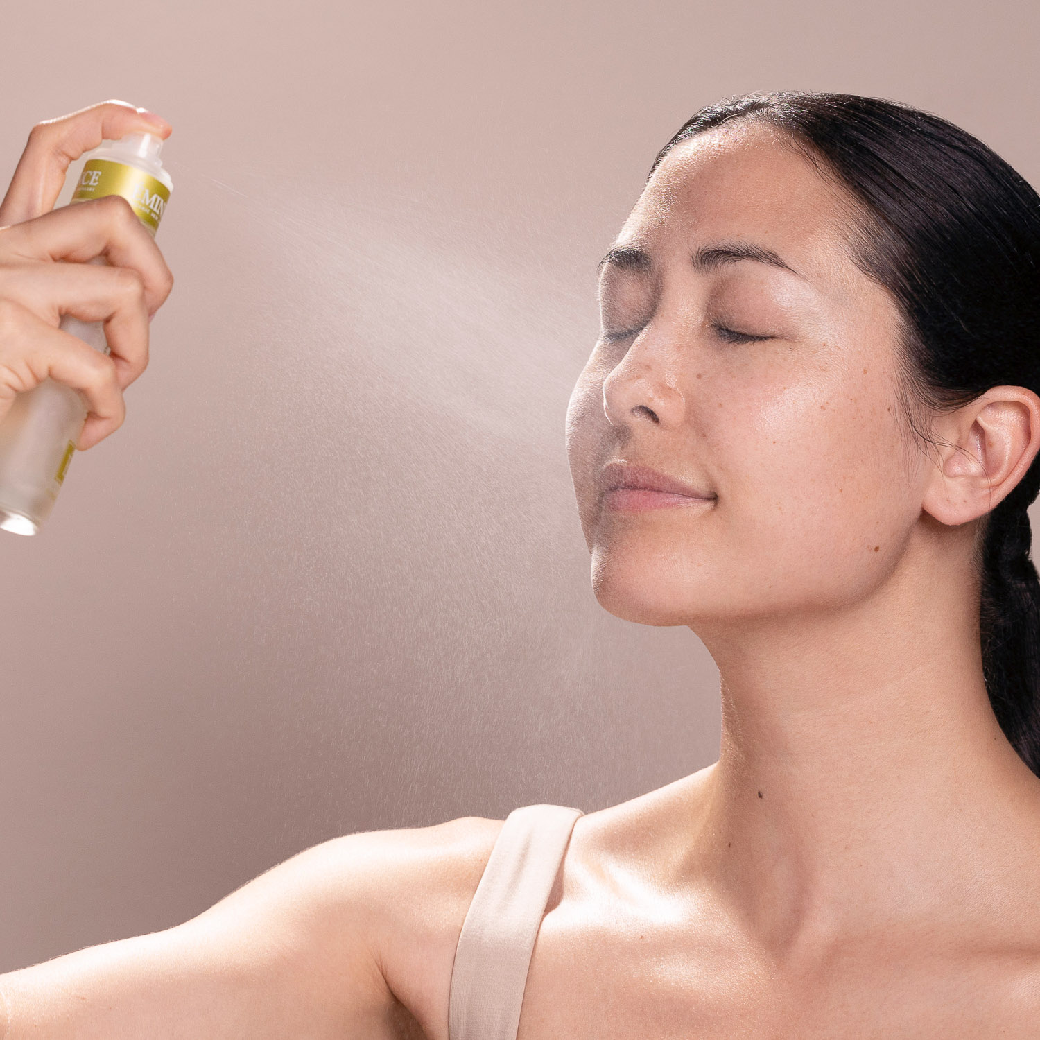 A woman misting the Eminence Organics Hawthorn Tonique onto her face