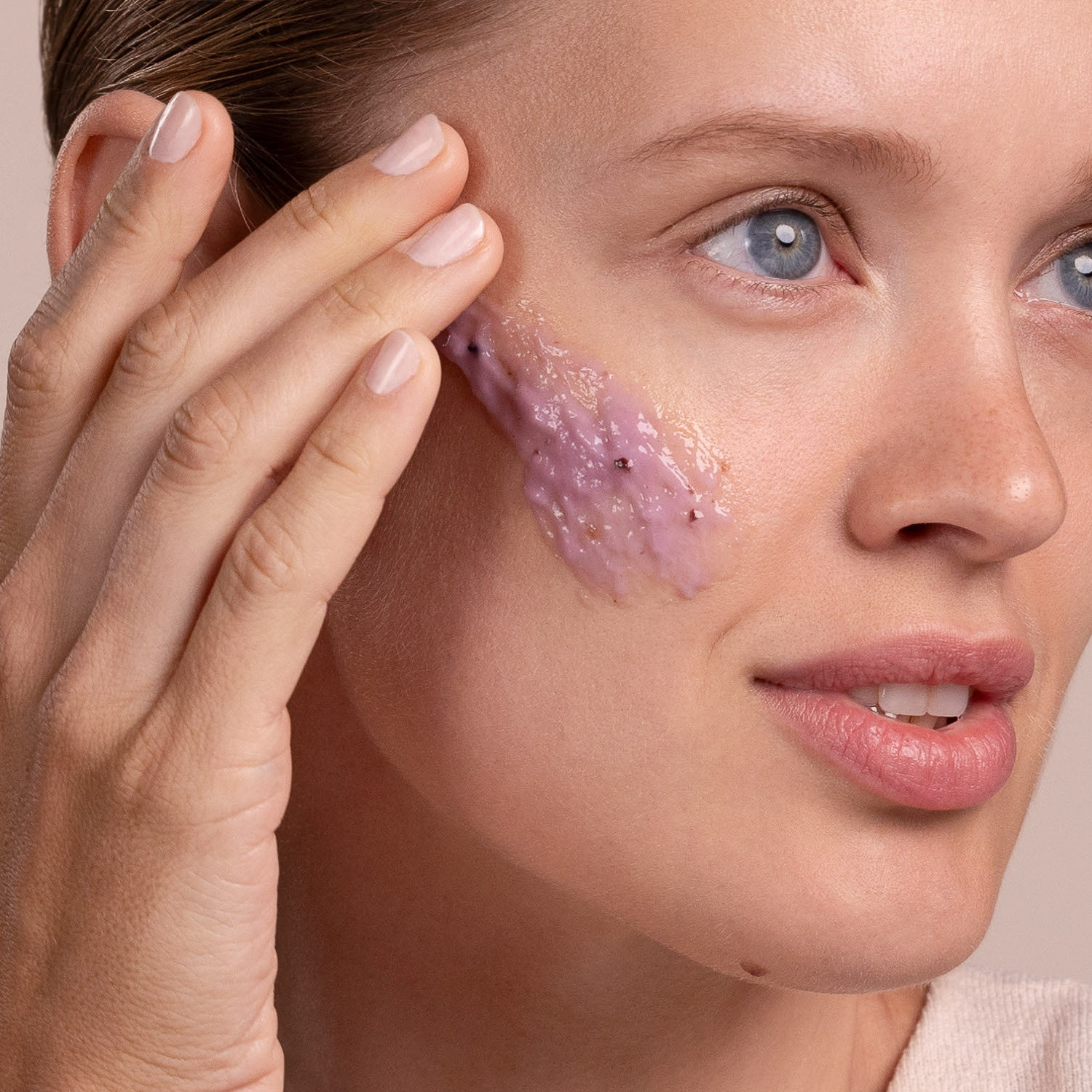A woman applying the Eminence Organics Firm Skin Acai Masque to her face