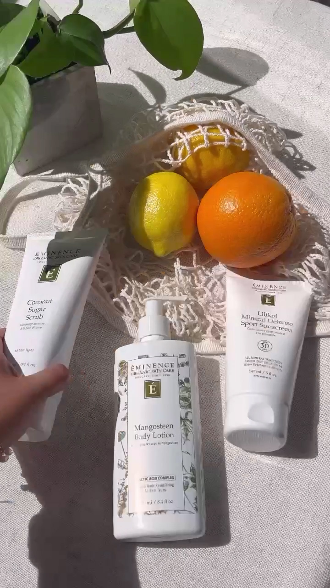 The Eminence Organics Lilikoi Mineral Defense Sport Sunscreen SPF 30 next to the Mangosteen Body Lotion and the Coconut Sugar Scrub