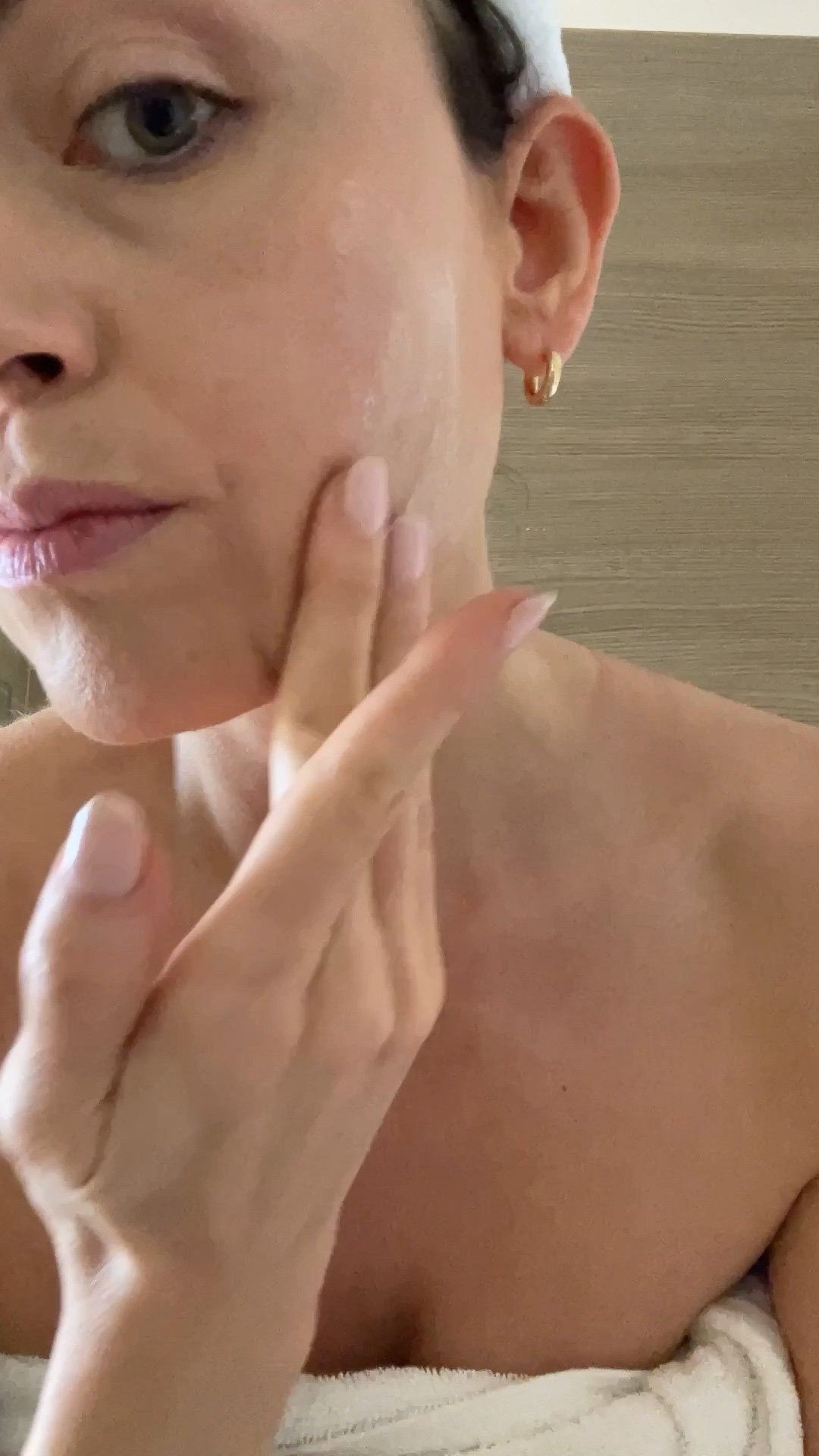 A woman applying the Eminence Organics Superfood Booster-Powder on her face