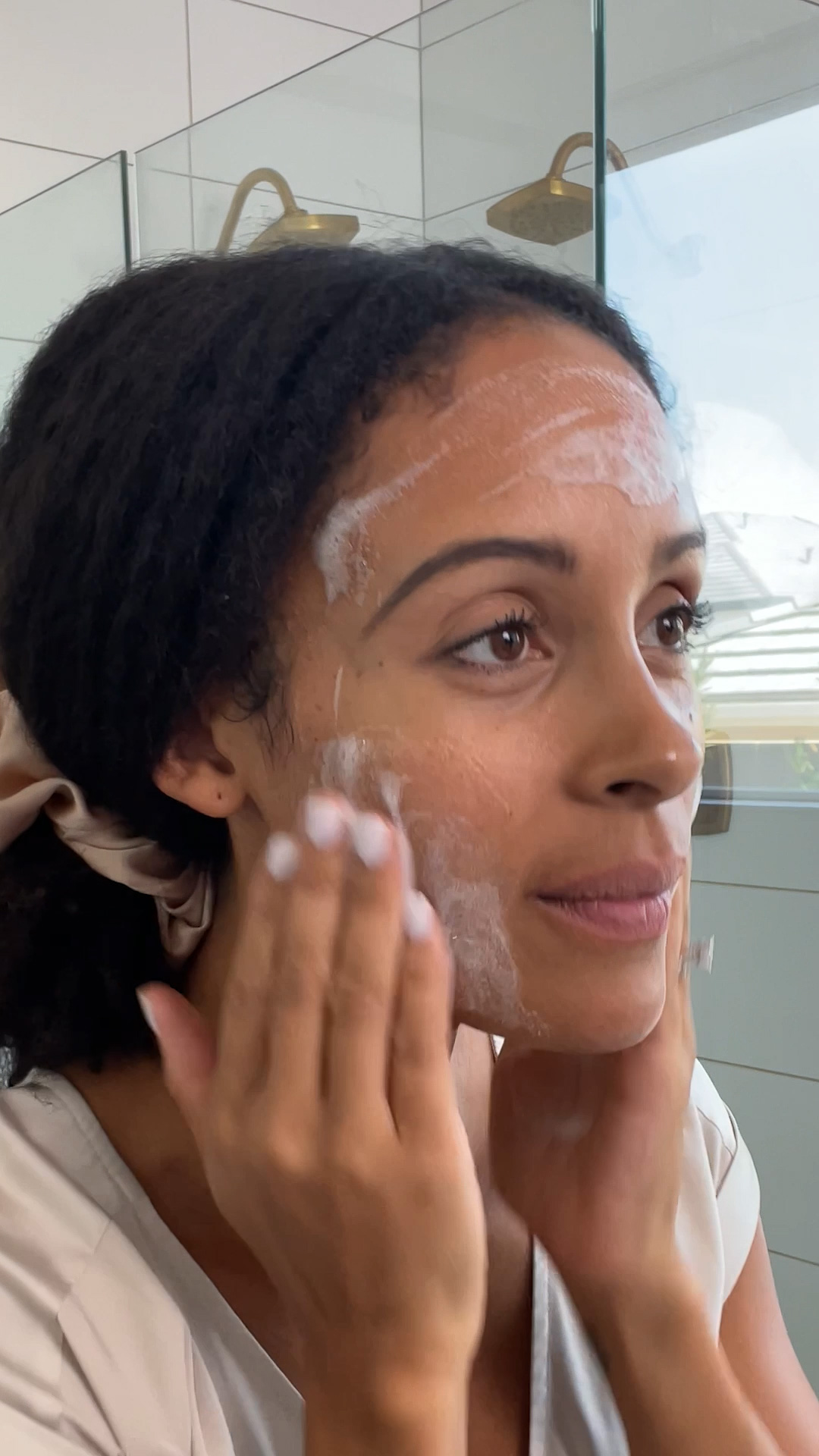 A woman applying Eminence Organics Acne Advanced Clarifying Hydrator on face