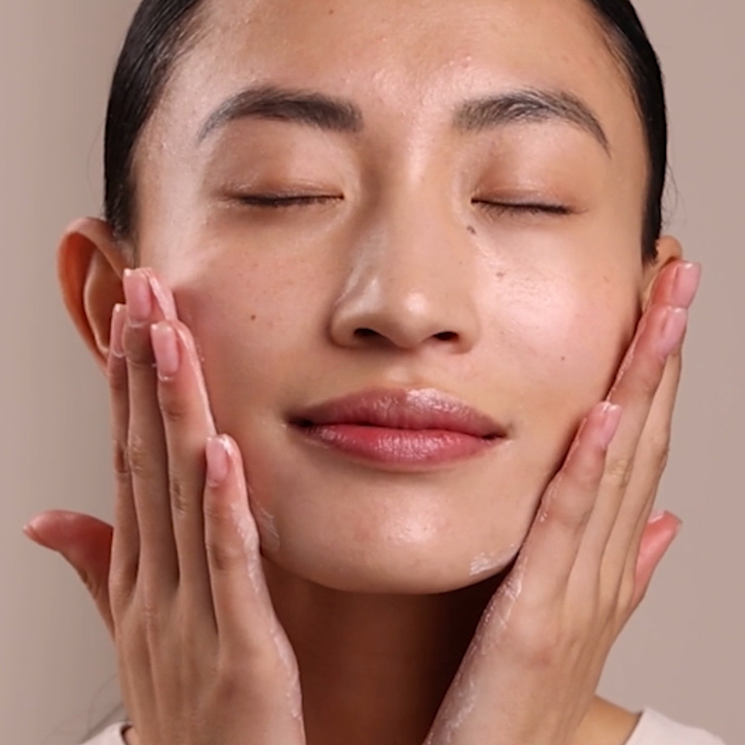 A woman applying Eminence Organics Arctic Berry Radiance Cream to face