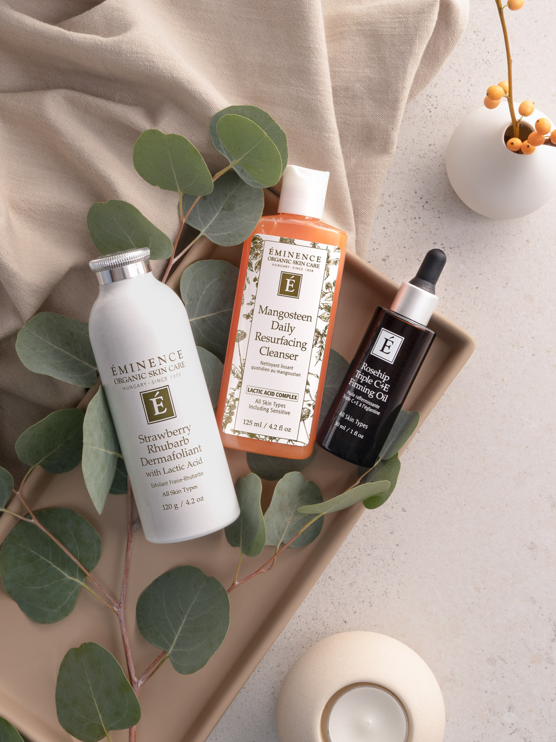 The Eminence Organics Mangosteen Daily Resurfacing Cleanser alongside the Strawberry Rhubarb Dermafoliant and the Rosehip Triple C+E Firming Oil