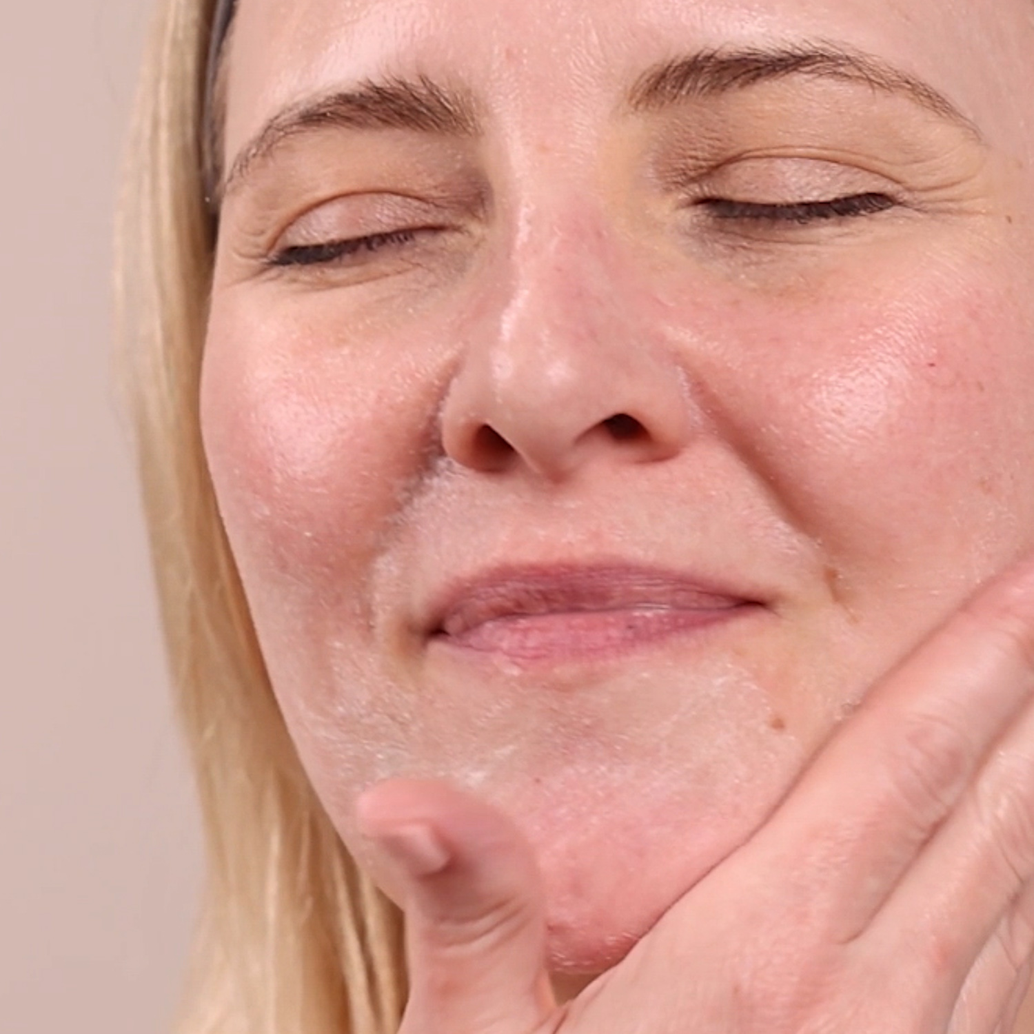 A woman applying Eminence Organics Charcoal Exfoliating Gel Cleanser to face