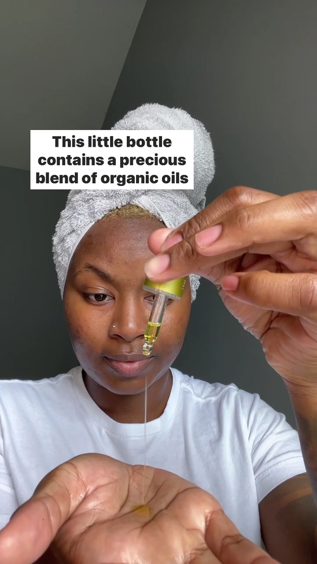 A woman applying Eminence Organics Citrus & Kale Potent C+E Serum to hand