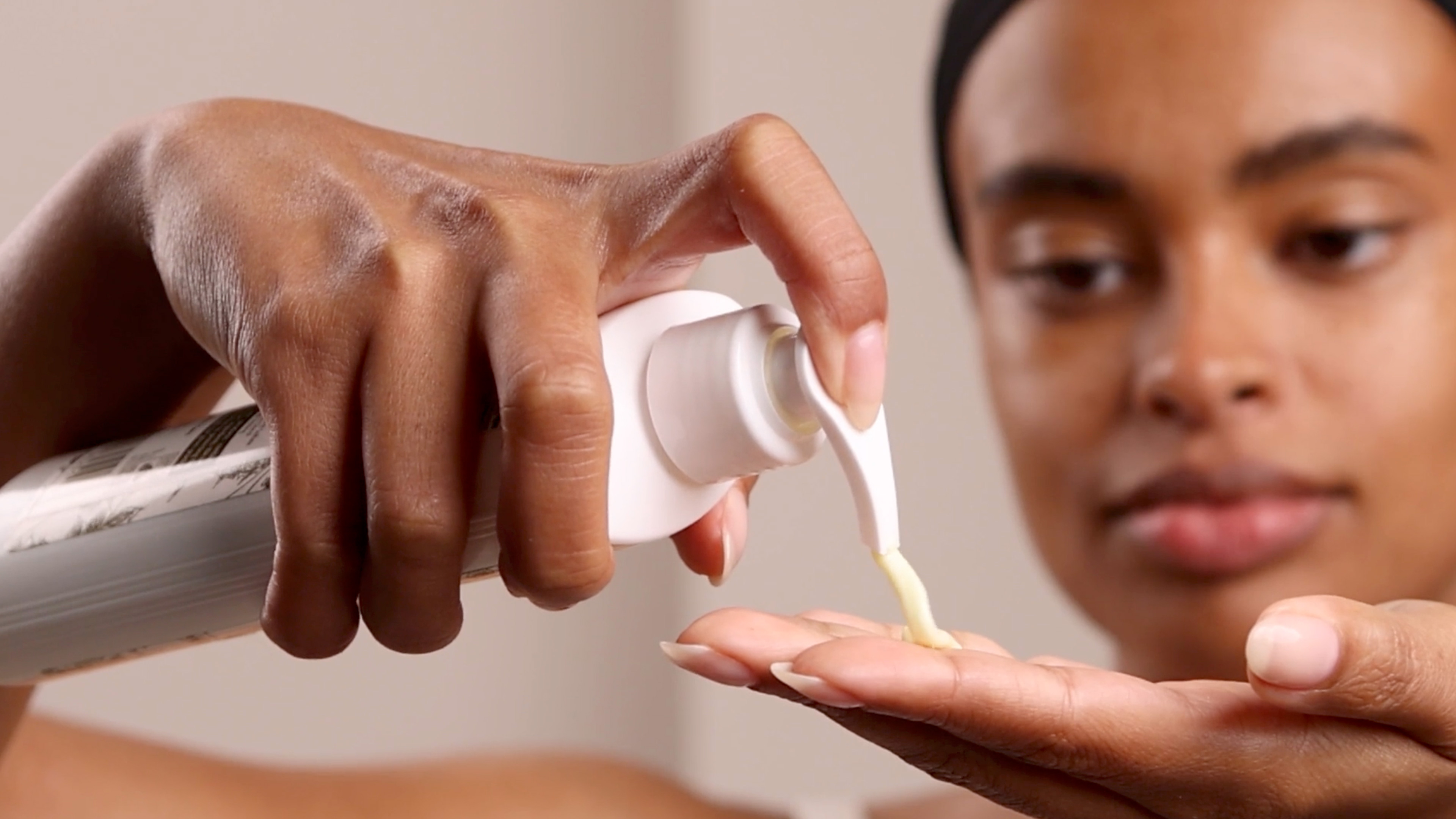 A woman applying Eminence Organics Calm Skin Chamomile Cleanser to hand