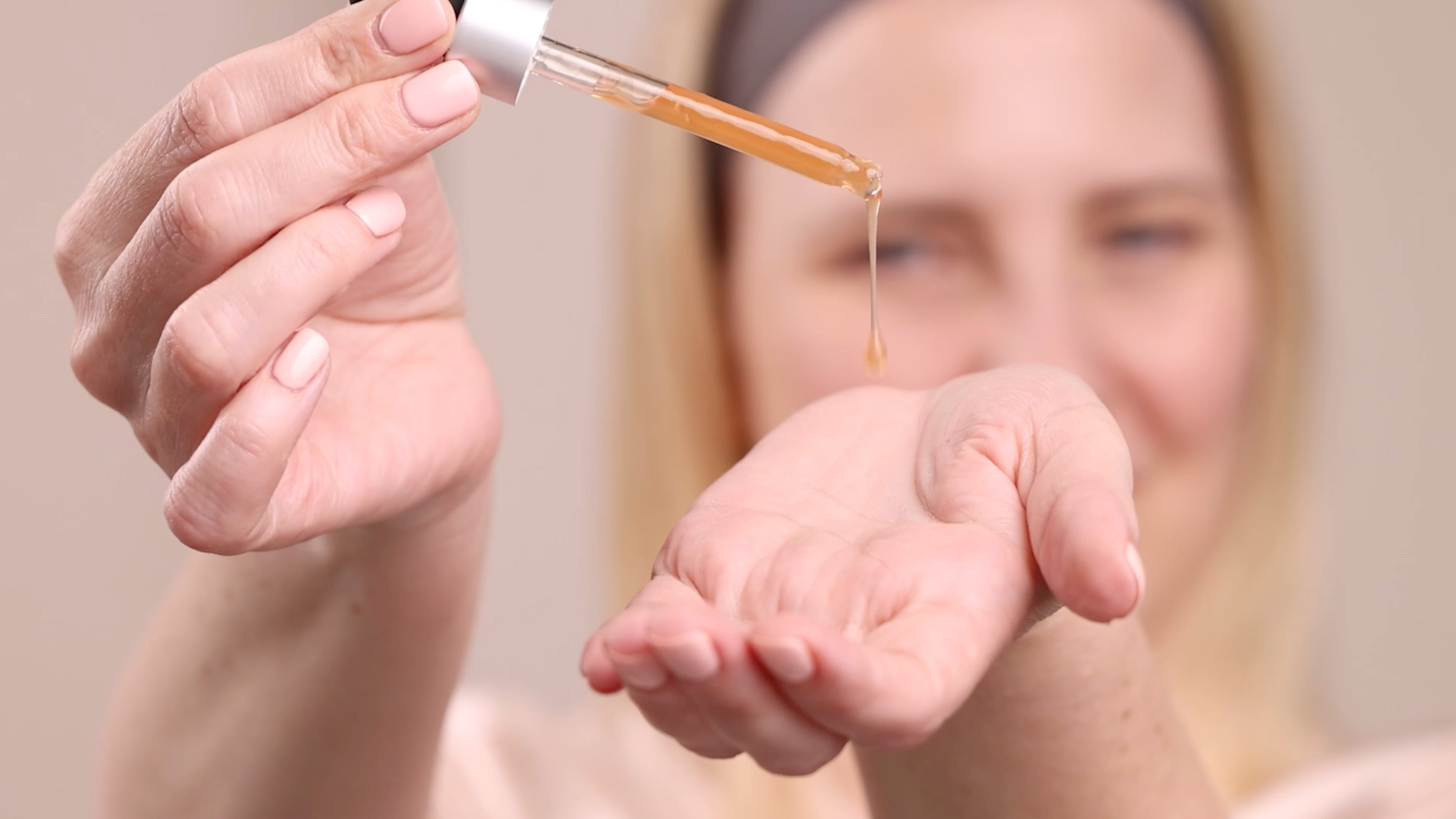 A woman applying Eminence Organics Calm Skin Arnica Booster-Serum to hand