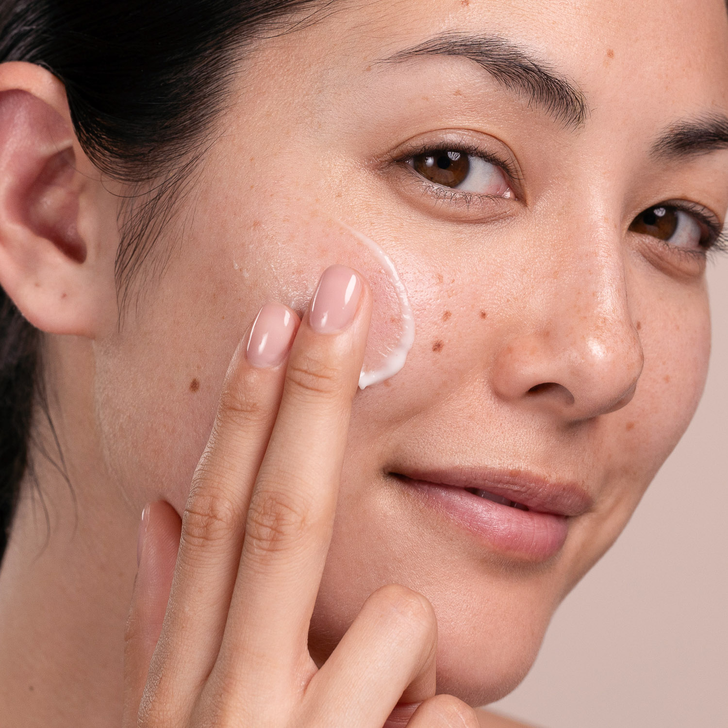 A woman applying the Eminence Organics Echinacea Recovery Cream to her face