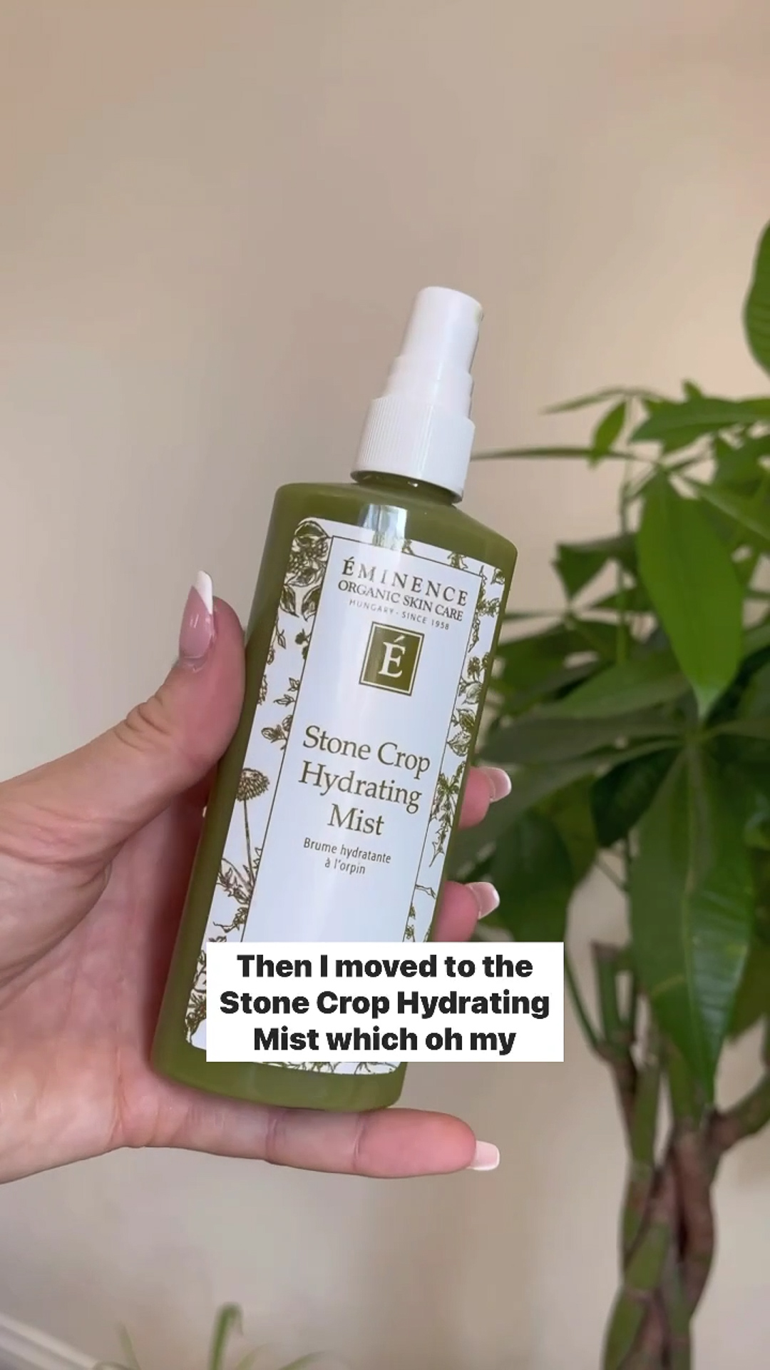 A hand holding the Eminence Organics Stone Crop Hydrating Mist