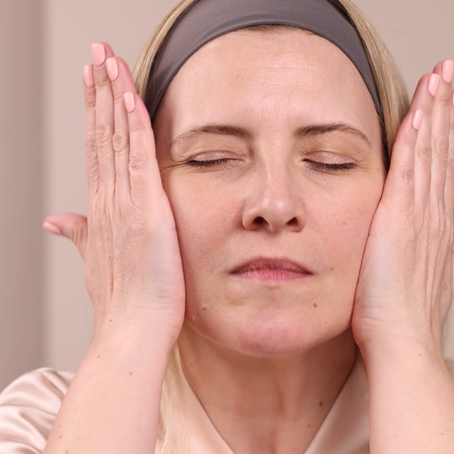 A woman applying Eminence Organics Calm Skin Arnica Booster-Serum to face