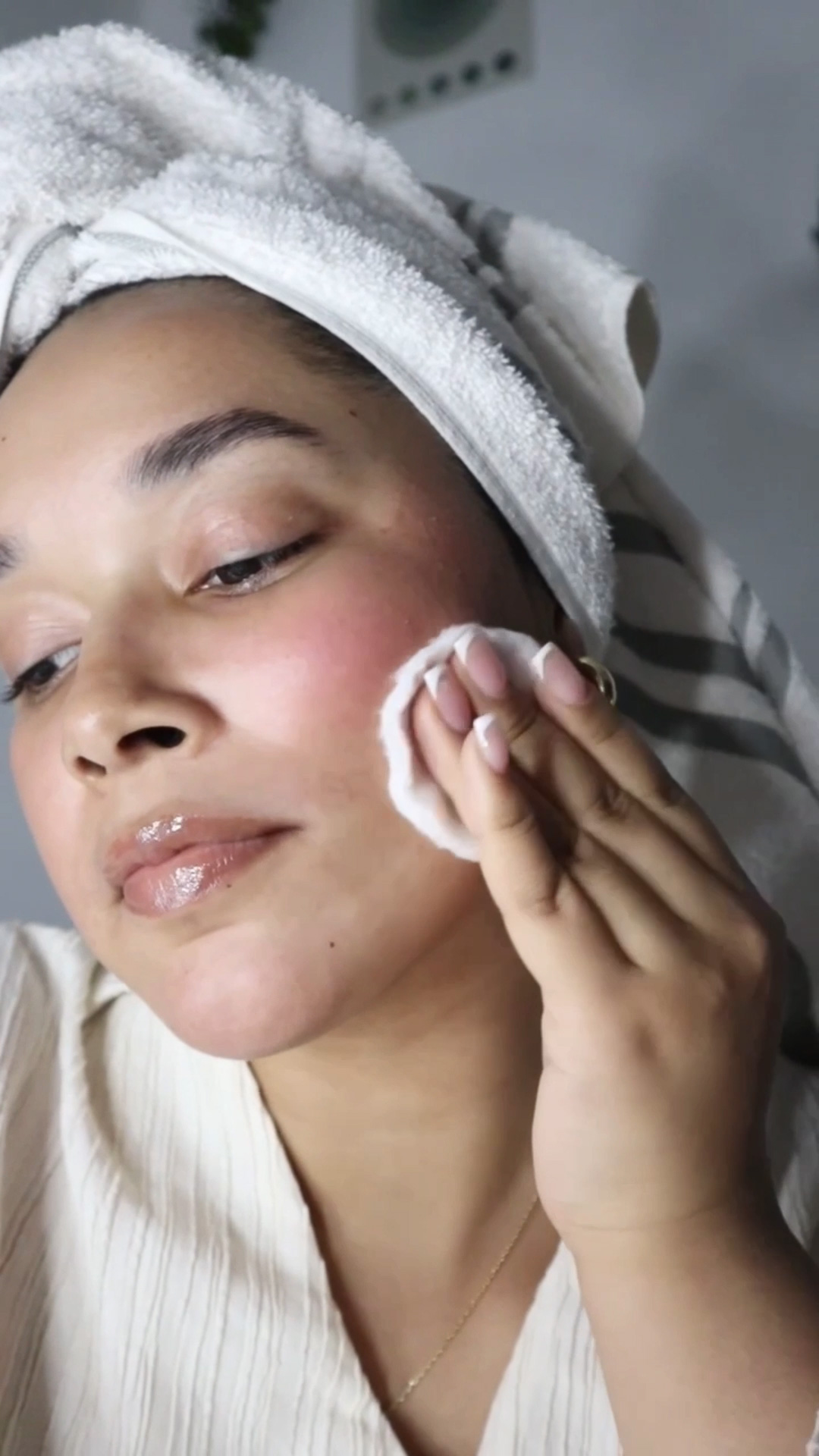 A woman applying Eminence Organics Calm Skin Chamomile Exfoliating Peel to face