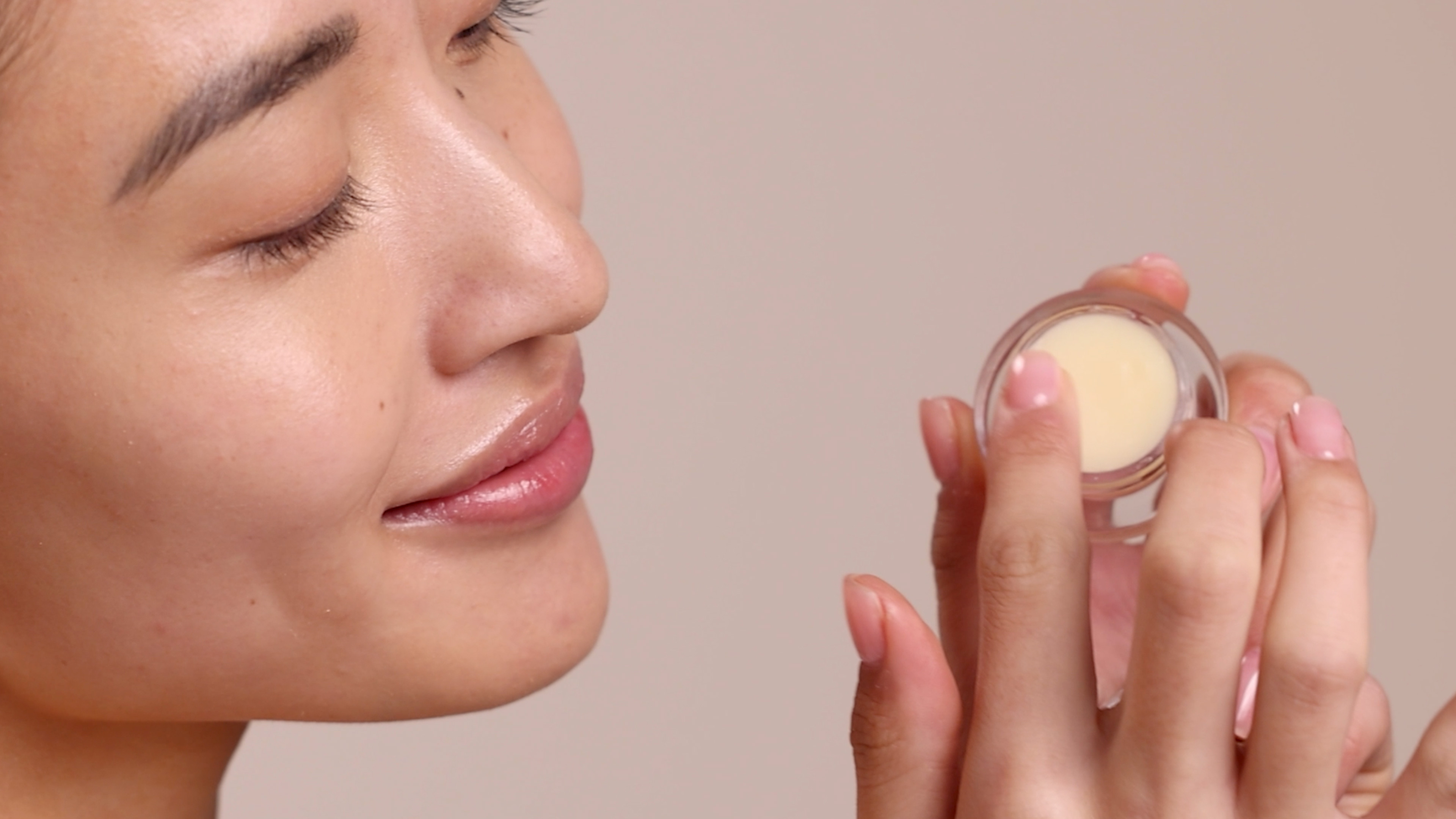 Woman holding Eminence Organics Citrus Lip Balm
