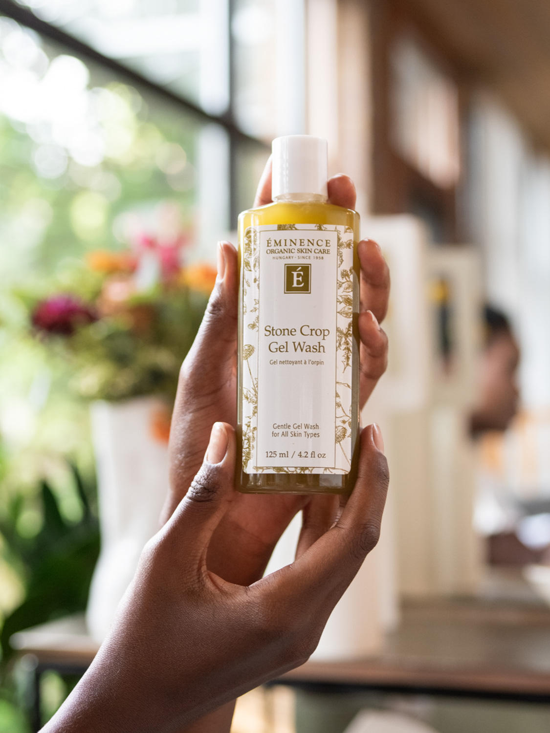 Hands holding the Eminence Organics Stone Crop Gel Wash