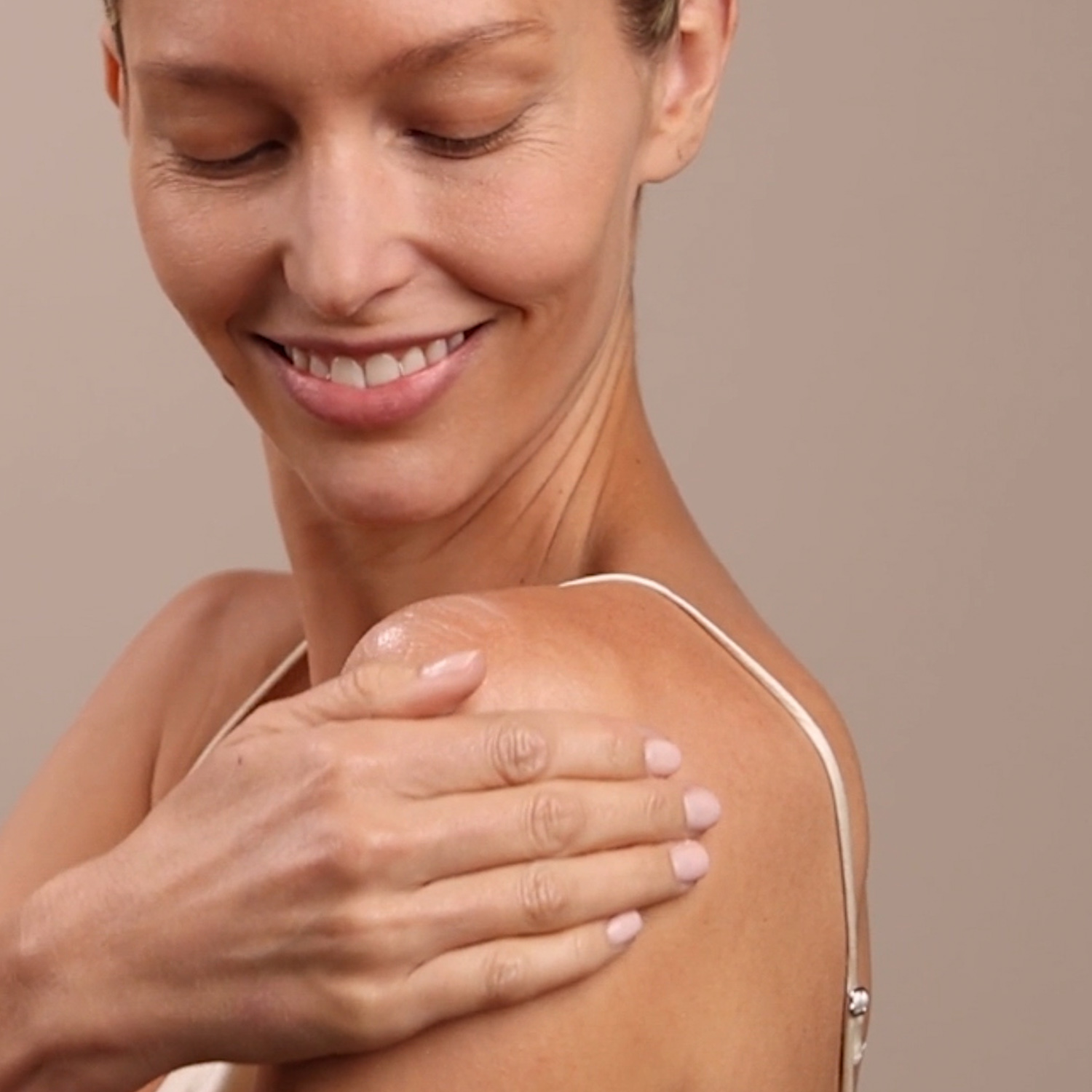 A woman applying the Eminence Organics Mangosteen Body Lotion onto their shoulder
