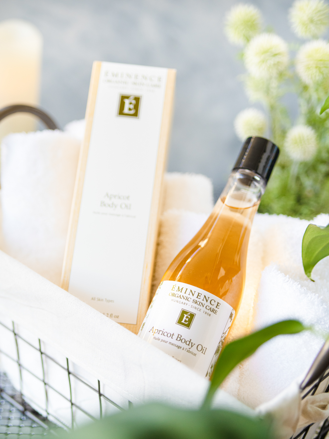 A basket holding Eminence Organics Apricot Body Oil