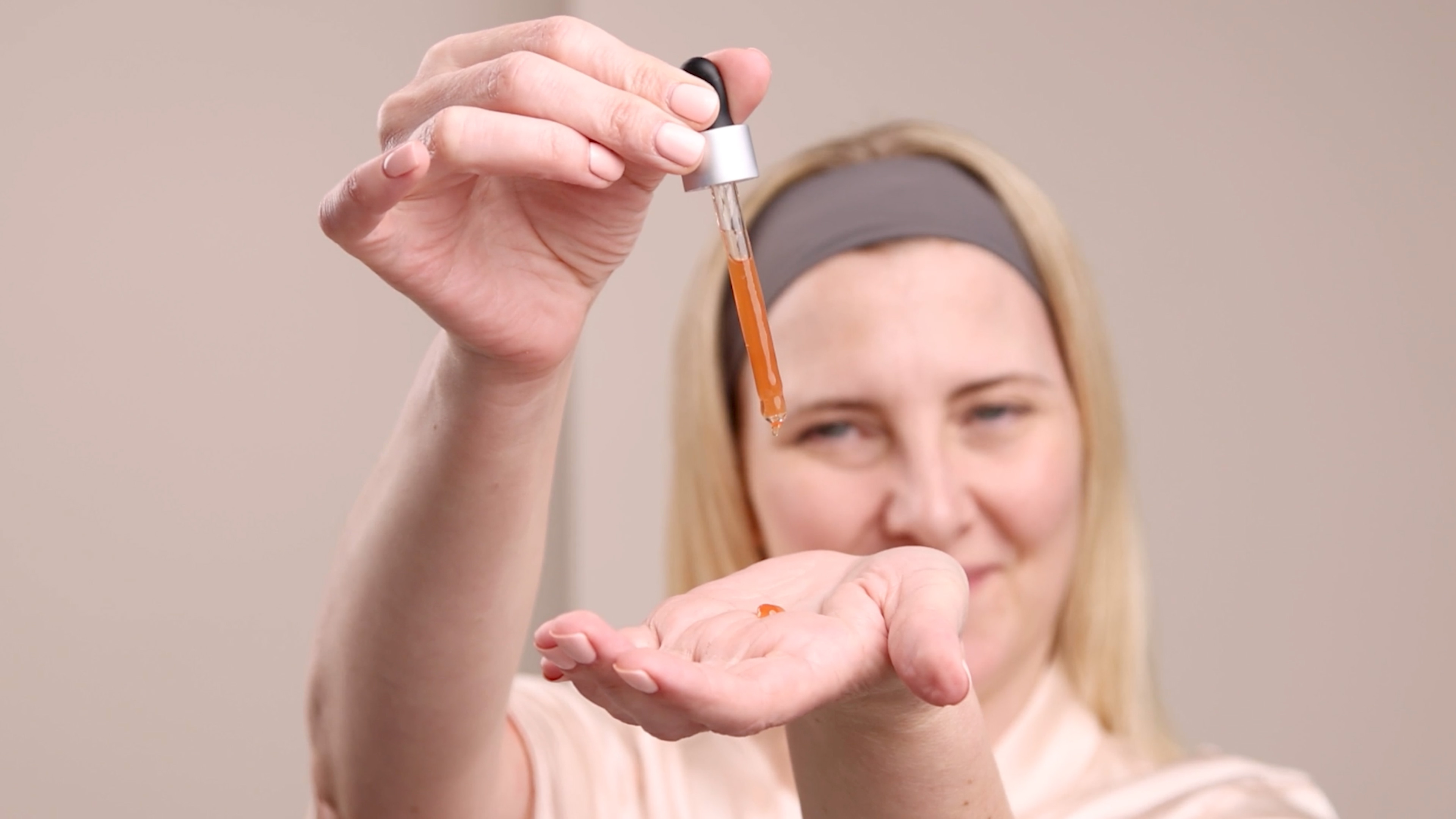 A woman applying Eminence Organics Clear Skin Bark Booster-Serum to hand