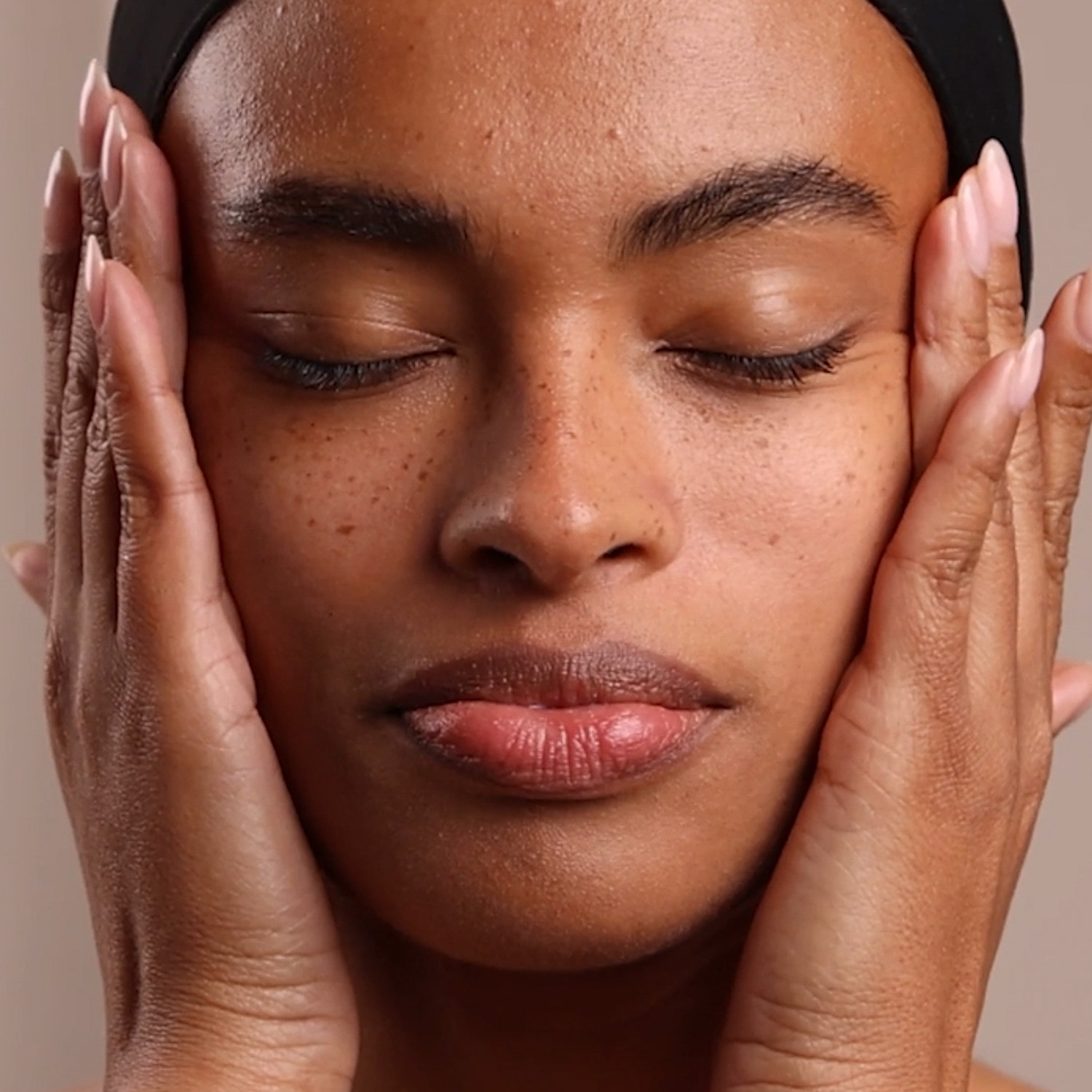 A woman applying Eminence Organics Bakuchiol + Niacinamide Moisturizer to face