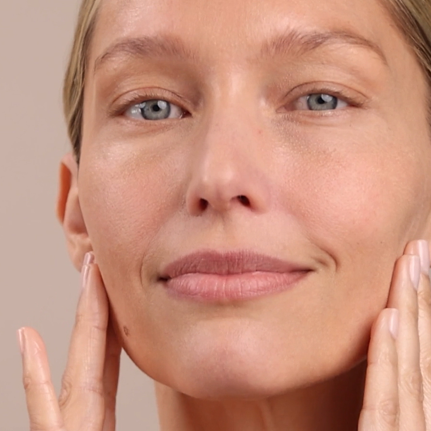 A woman applying the Eminence Organics Stone Crop Serum on her face