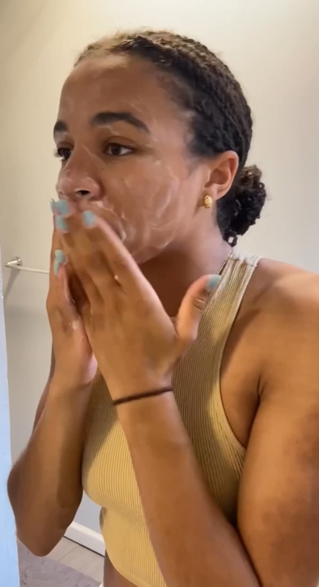 A woman applying Eminence Organics Pineapple Refining Tonique on her face