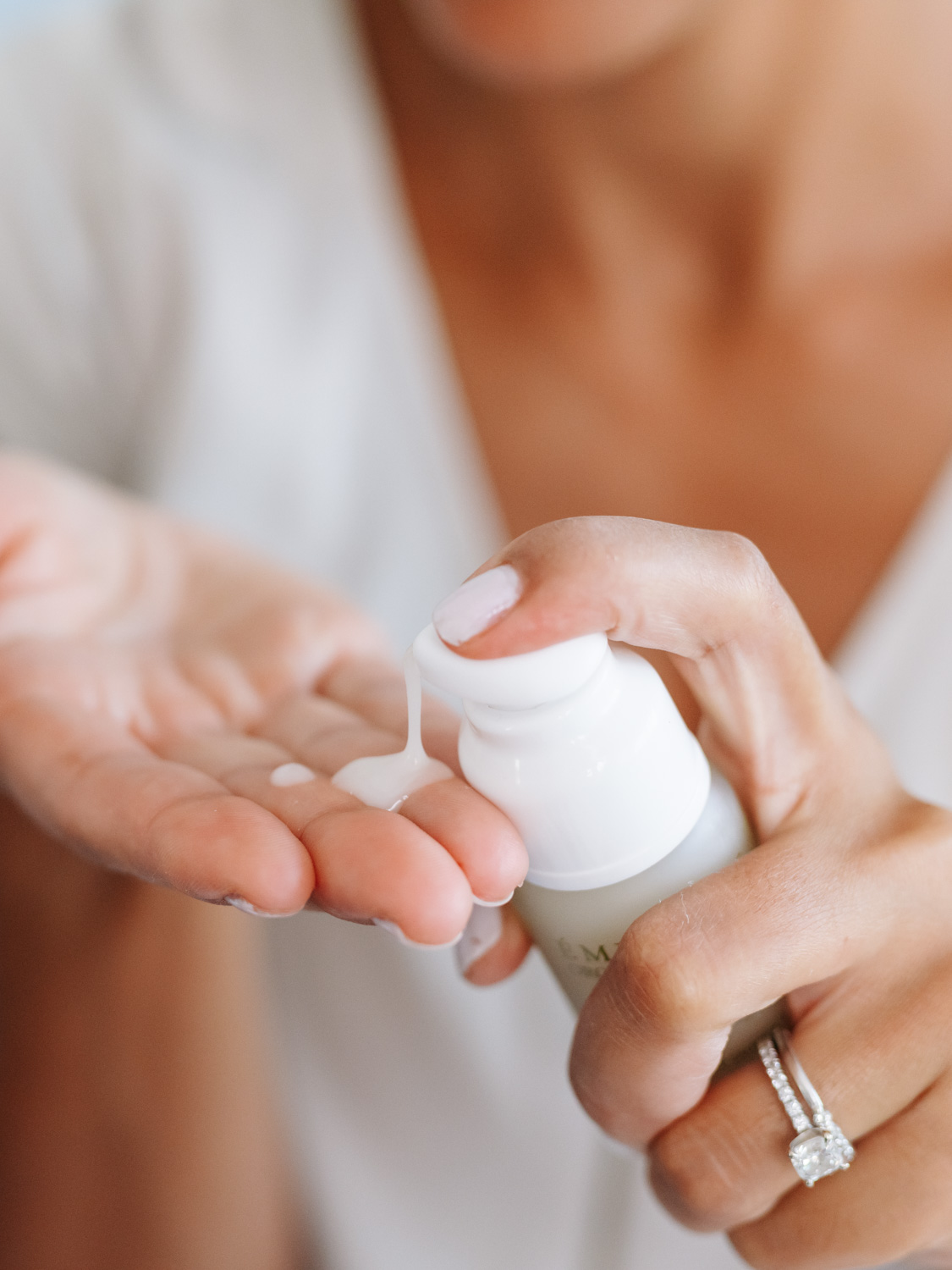 A woman applying Eminence Organics Acne Advanced Clarifying Hydrator on hand
