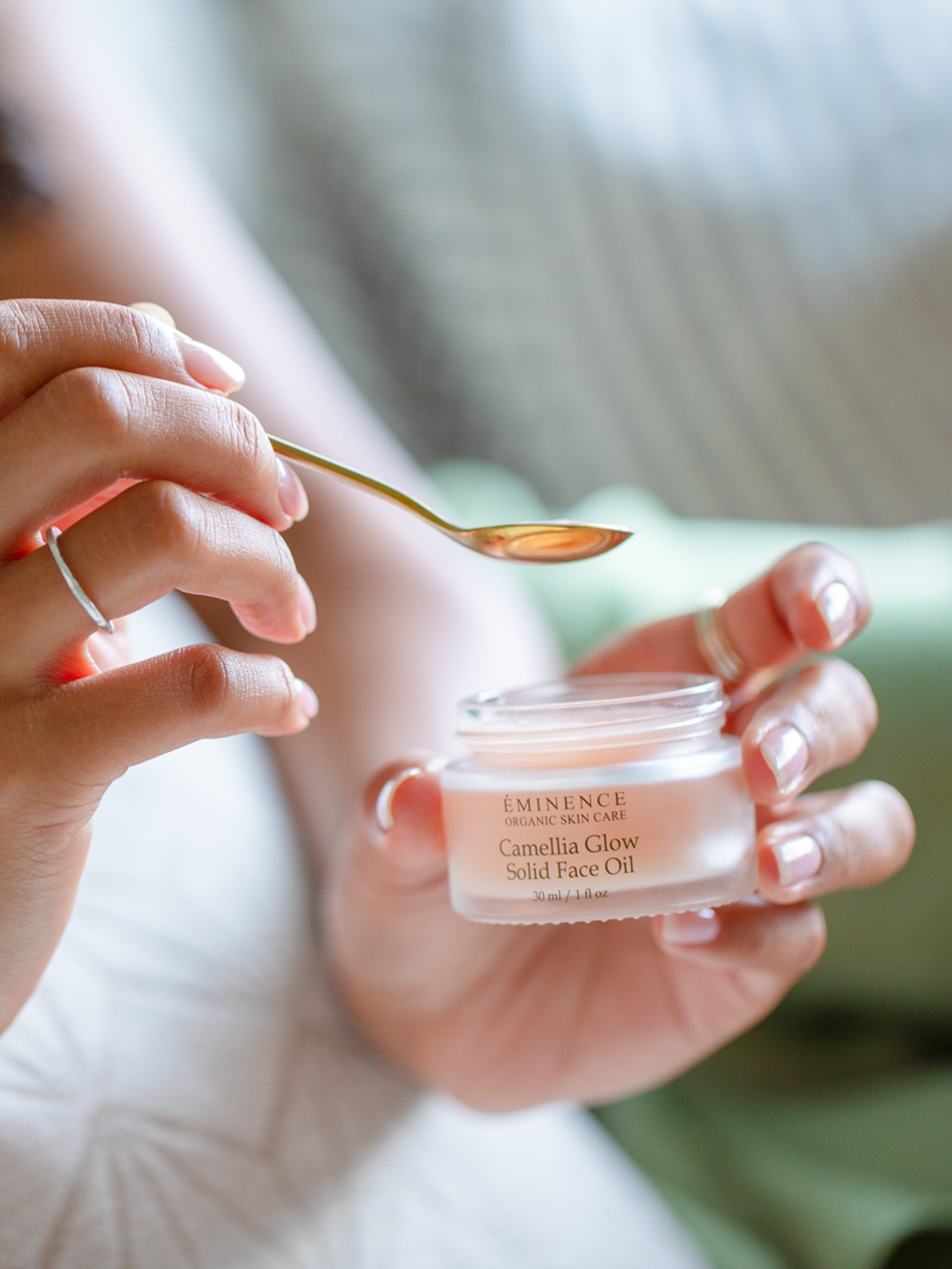 A woman holding Eminence Organics Camellia Glow Solid Face Oil