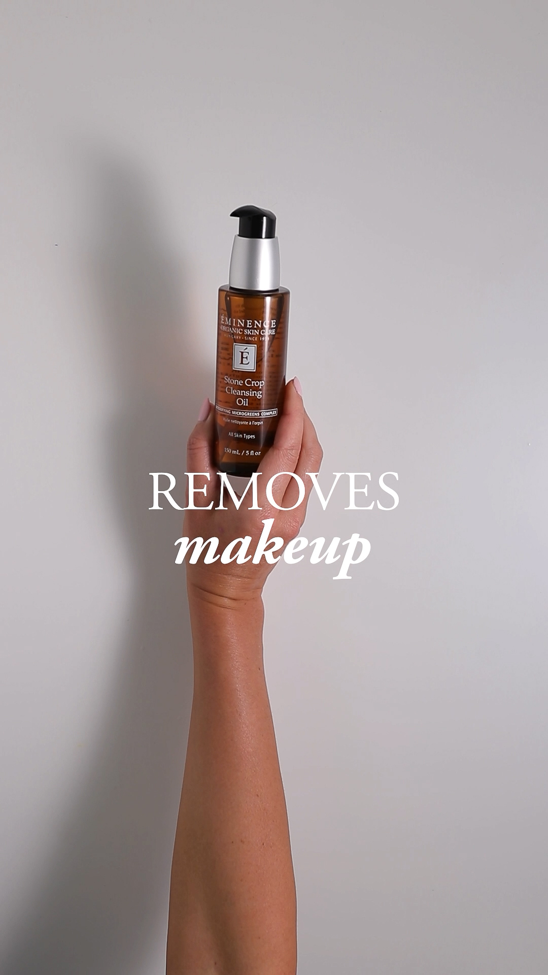 A hand holding the Eminence Organics Stone Crop Cleansing Oil