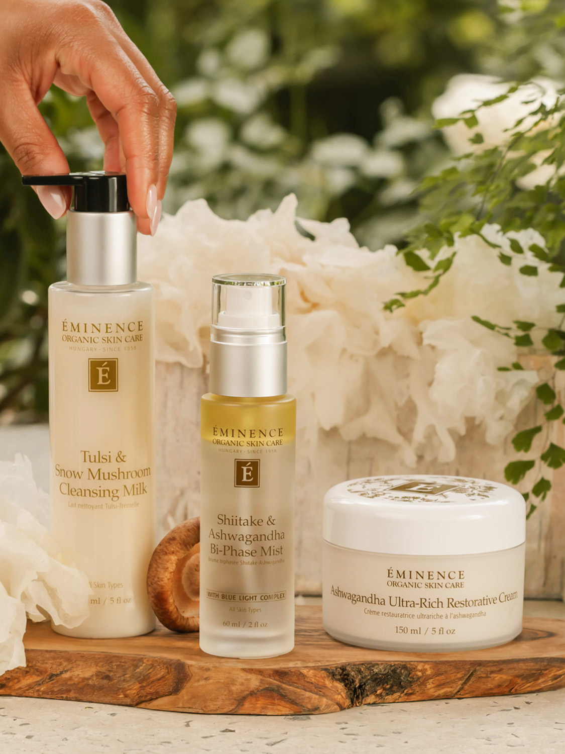 A woman reaching for the Eminence Organics Tulsi & Snow Mushroom Cleansing Milk 