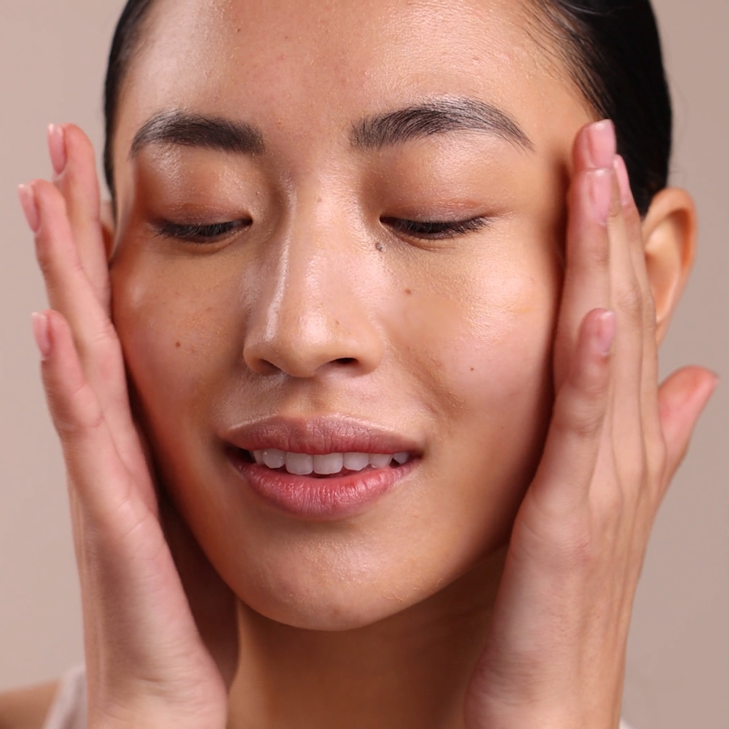 A woman applying Eminence Organics Charcoal & Black Seed Clarifying Oil to face