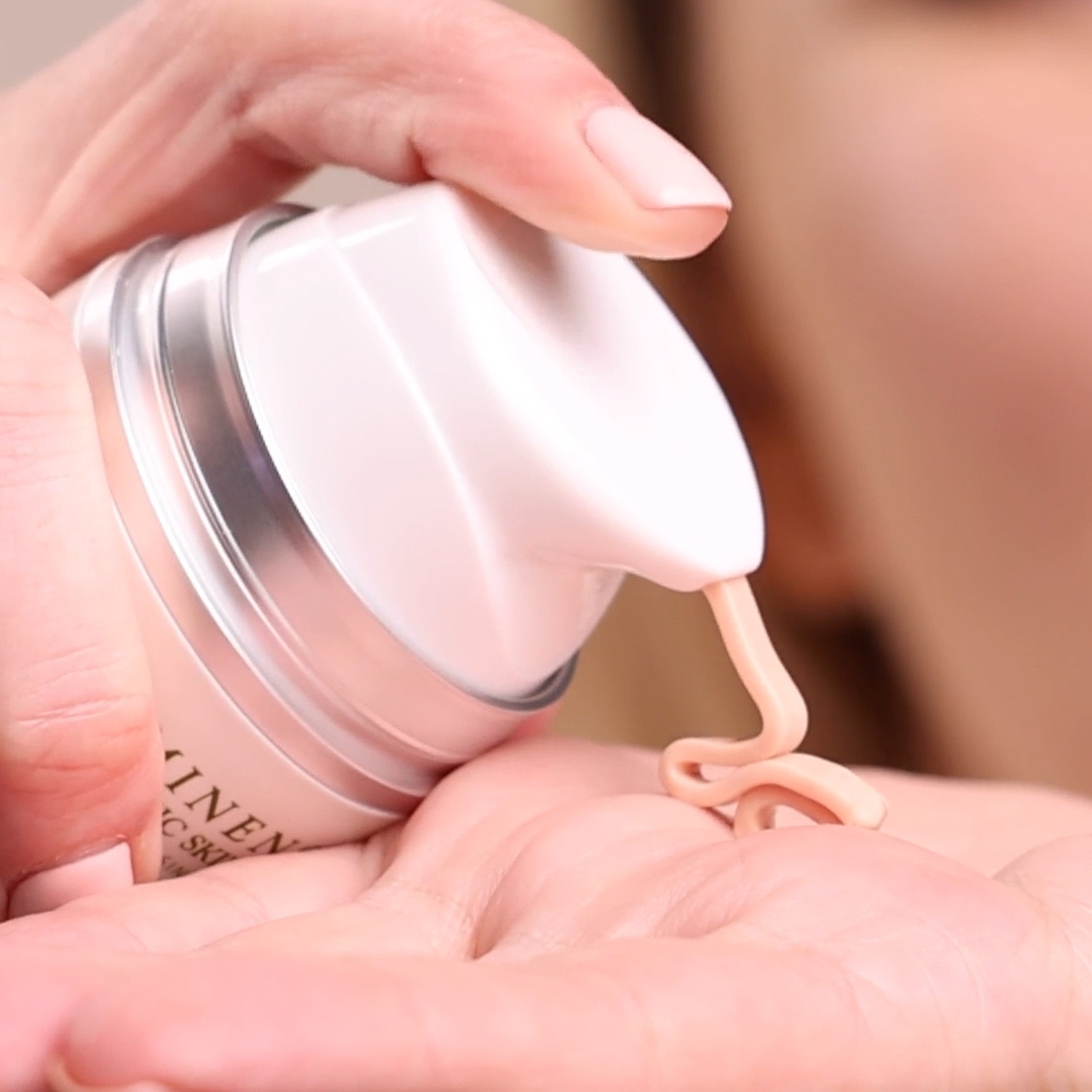 A woman applying the Eminence Organics Hibiscus Ultra Lift Neck Cream onto the palm of her hand