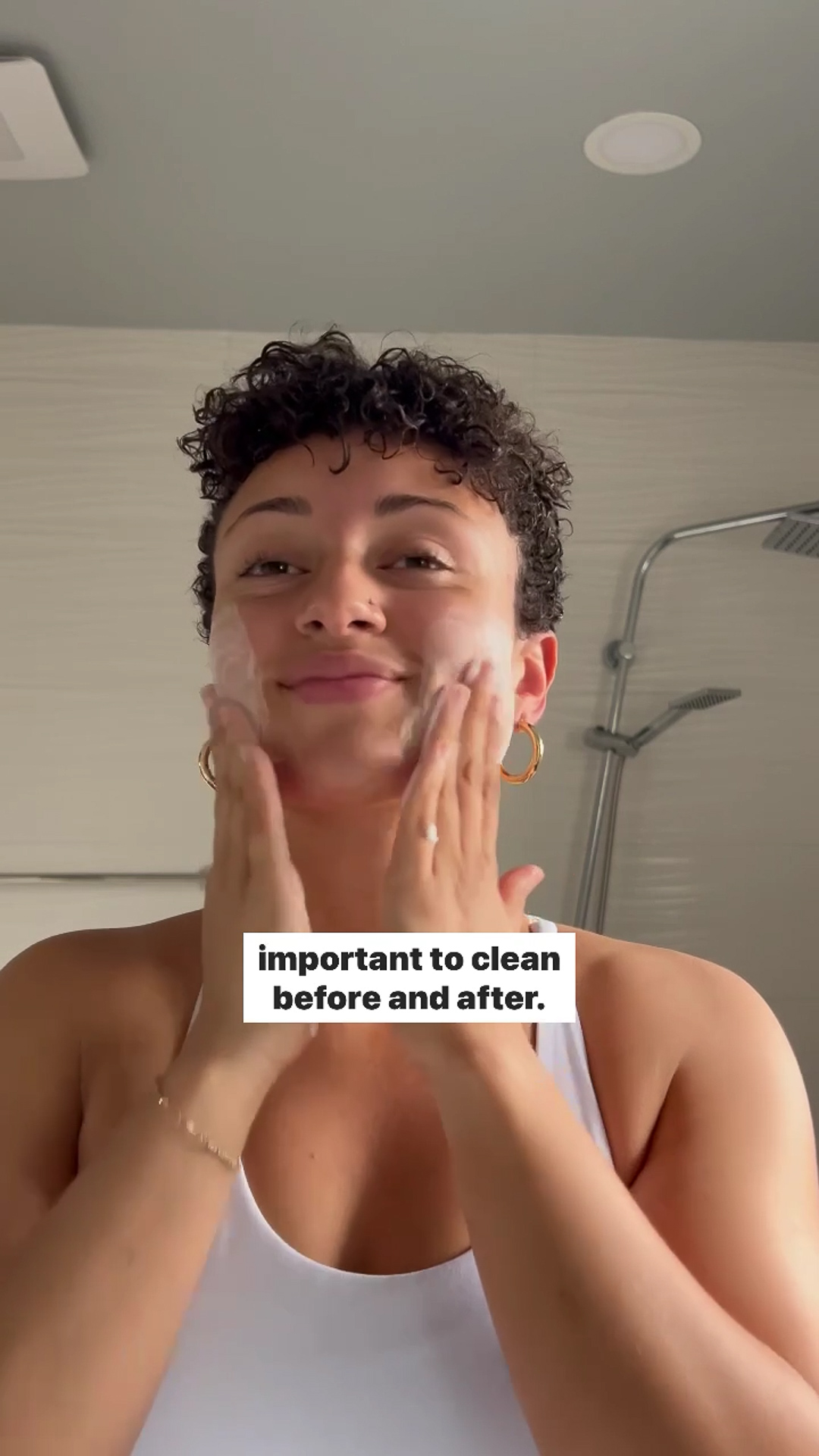 A person cleansing their face with the Eminence Organics Kombucha Microbiome Foaming Cleanser