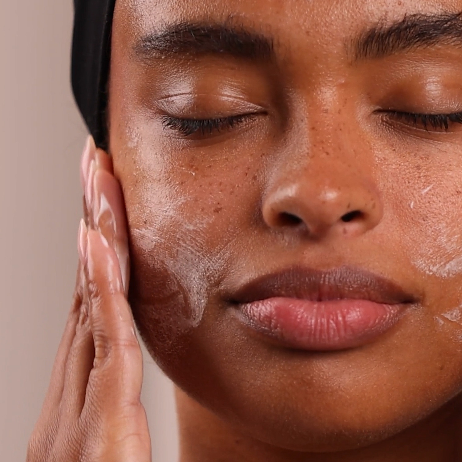 A woman with a swatch of the Eminence Organics Stone Crop Gel Wash Swatch on her face