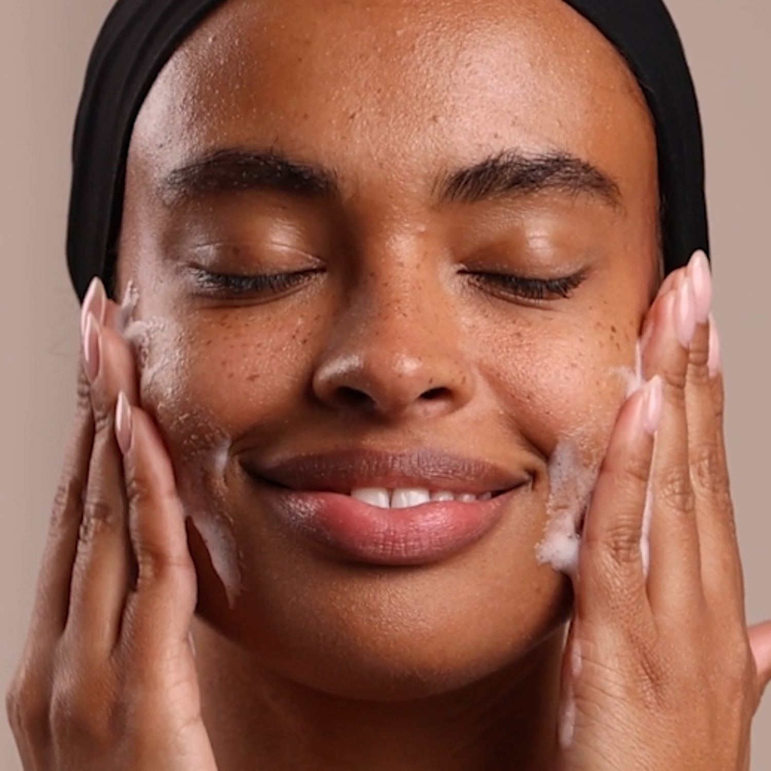 A woman applying Eminence Organics Radiance Renewal Set Limited Edition to her face